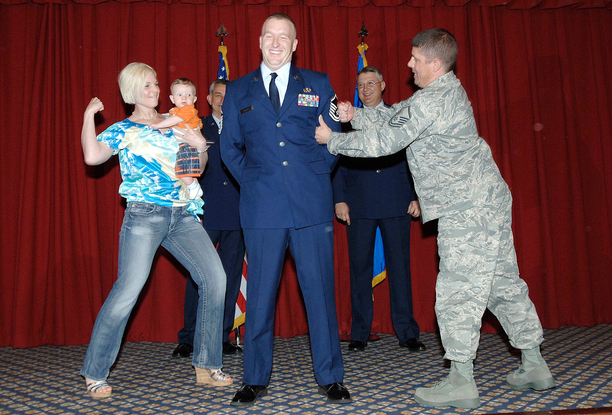 FAIRCHILD AIR FORCE BASE, Wash. – Master Sgt. Dennis Austin, 92nd Maintenance Operations Squadron, receives love taps from wife Allison and Master Sgt. Todd Berliner, 92nd MOS, as his son Zachary looks on during the promotion ceremony. This event was held at Club Fairchild May 30. (U.S. Air Force photo / Staff Sergeant JT May III)