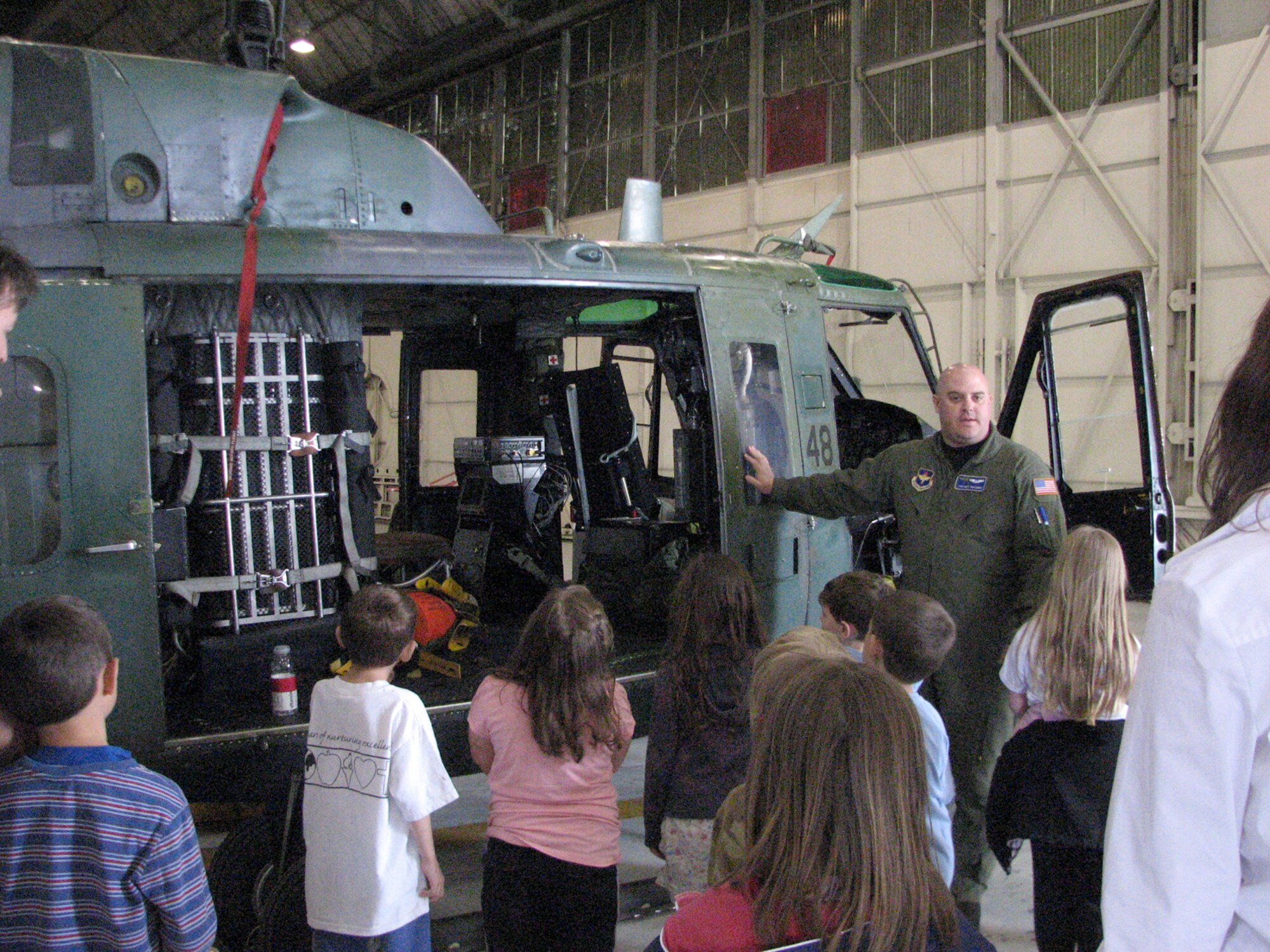 FAIRCHILD AIR FORCE BASE, Wash. – Tech. Sgt. Matthew Ryplewski of the 36th Rescue Flight leads a helicopter tour May 29. Twelve students and seven chaperones from North Wall Elementary school in Spokane, Wash., toured the helicopter, Fire Station 1 and the 92nd Operations Support Squadron life support section. (U.S. Air Force photo / Staff Sgt. Connie L. Bias)
