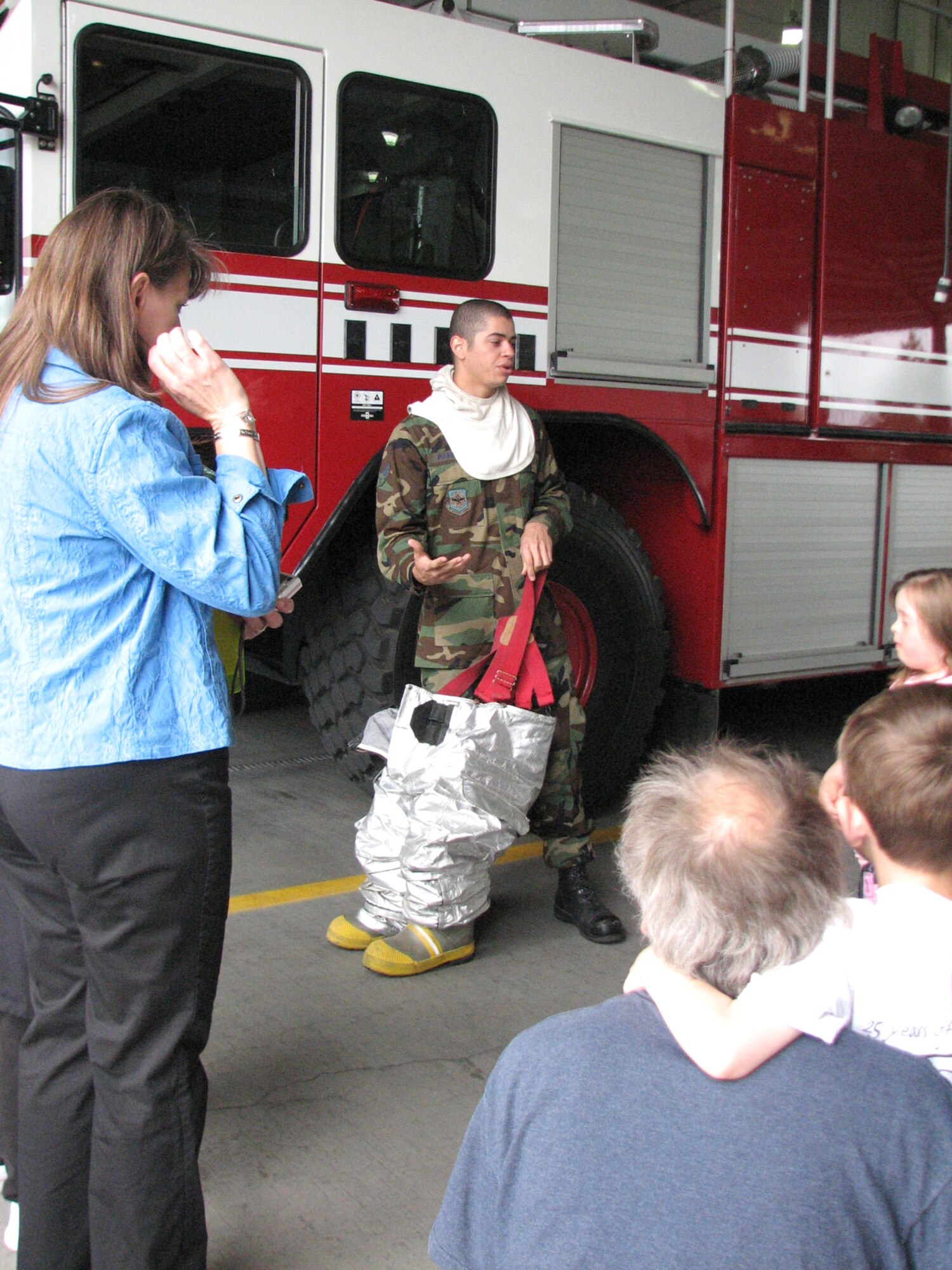 FAIRCHILD AIR FORCE BASE, Wash. – Senior Airman Alex Parrish, 92nd Civil Engineer Squadron firefighter, explains the wear and uses of a firefighter’s gear. Airman Parrish was a tour leader for 12 Spokane, Wash., North Wall Elementary School students May 29. At Fire Station 1, the children, ranging in age from 6 to 8, also got a close-up look at the station’s emergency call center, and were able to see a fire truck’s impressive water-spraying capabilities. (U.S. Air Force photo / Staff Sgt. Connie L. Bias)