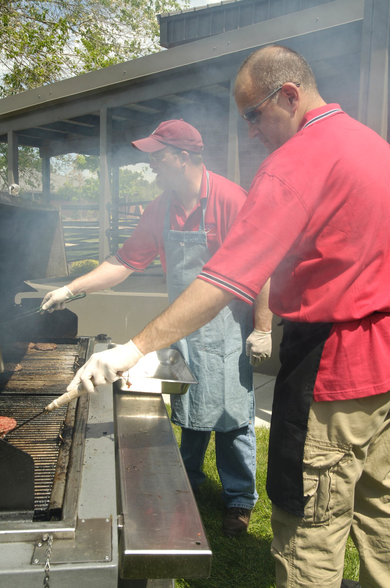 FAIRCHILD AIR FORCE BASE, Wash. – Master Sgts. Scott Woller and Brian Bennett, 92nd Mission Support Squadron, grill hamburgers during the Spouse’s Appreciation Day cookout at the Airman & Family Readiness Center May 30. (U.S. Air Force photo / Senior Airman Eunique Stevens)