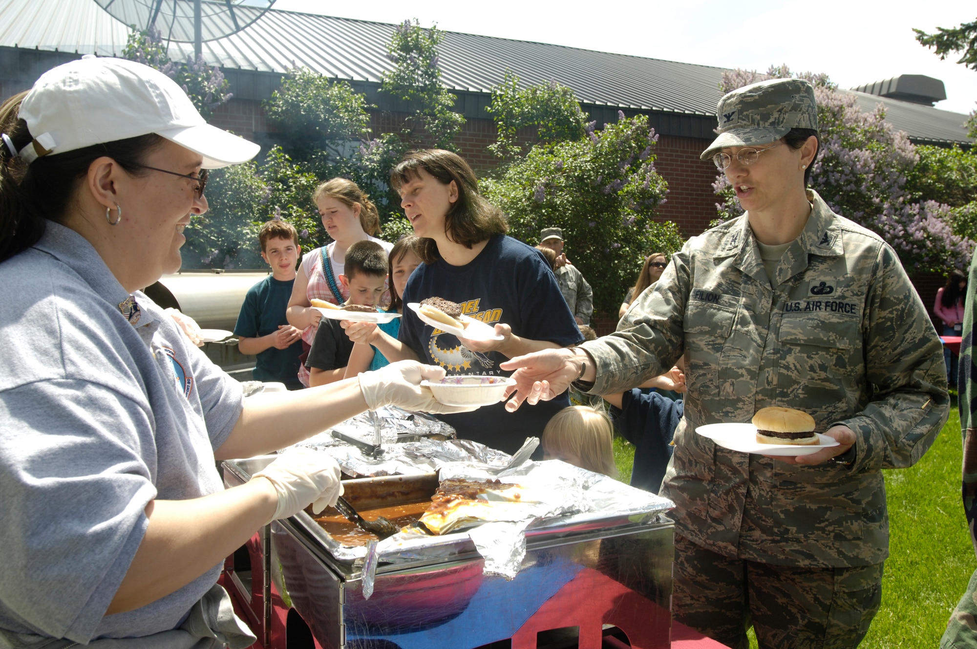 FAIRCHILD AIR FORCE BASE, Wash. – Maria Knight serves Col. Suzanne Filion, 92nd Mission Support Group commander, during the Spouse’s Appreciation Day cookout at the Airman & Family Readiness Center May 30. (U.S. Air Force photo / Senior Airman Eunique Stevens)