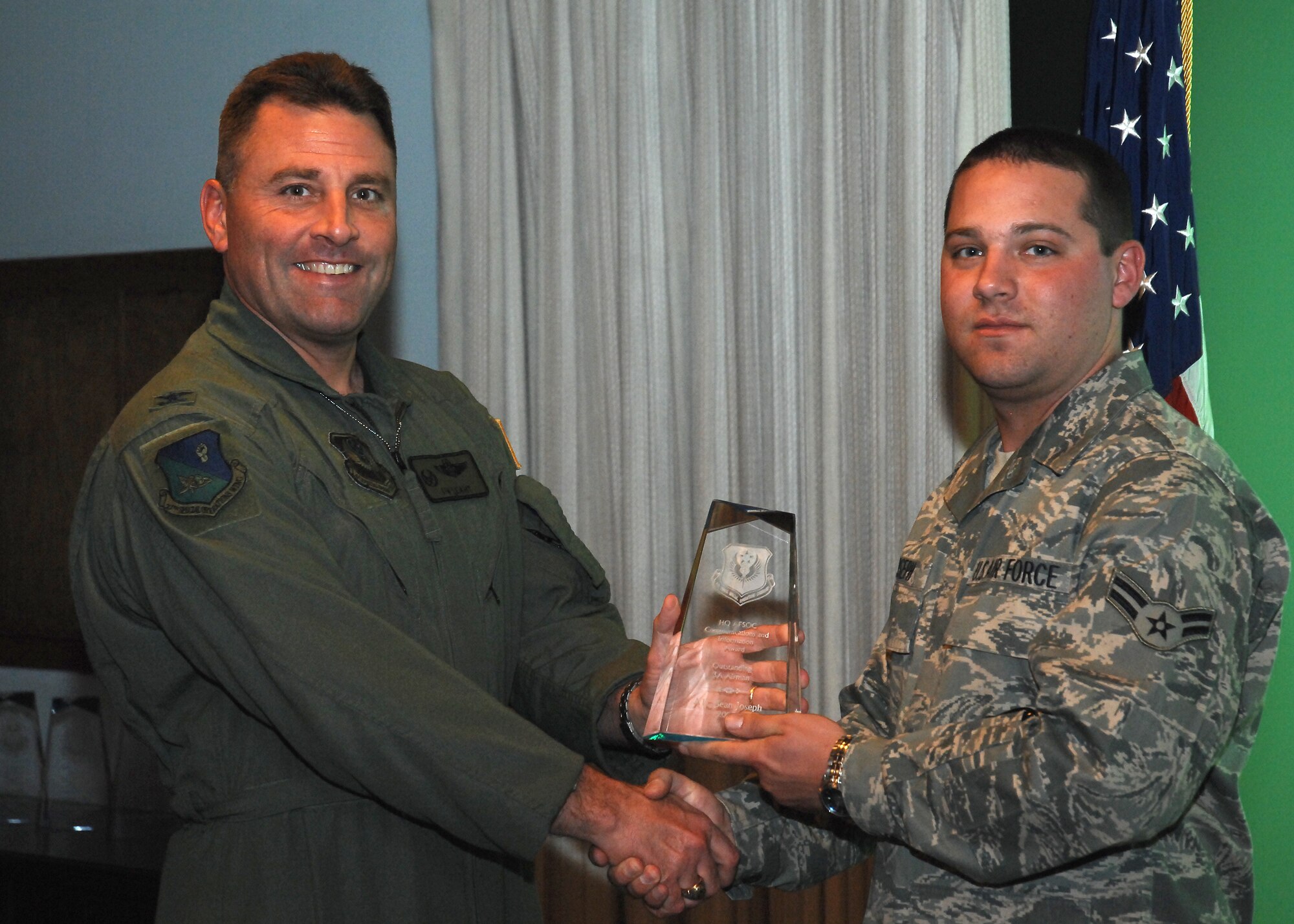 CANNON AIR FORCE BASE, N.M. --  Airman 1st Class Sean Joseph, 27th Special Operations Communications Squadron, receives the Information Management Outstanding Airman Award presented by Col. Timothy Leahy, 27th Special Operations Wing commander.  Airman Joseph received the award at the weekly wing staff meeting on June 4.  (U.S. Air Force photo/Senior Airman Liliana Moreno)