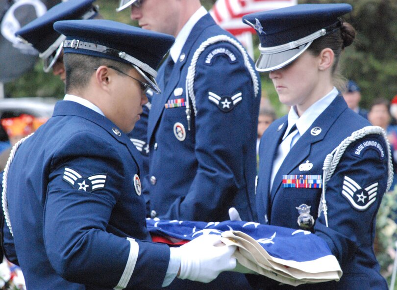 Senior Airman Andrew Yu, 90th Security Forces Squadron, Staff Sgt. Lisa Haskins, 90th Security Support Squadron, and other members of the Warren Honor Guard perform a flag folding ceremony at the Memorial Day wreath laying ceremony May 26 at Beth El Cemetery in Cheyenne. The Warren Honor Guard performed at many Memorial Day functions (Photo by 2nd Lt. Lisa Meiman).