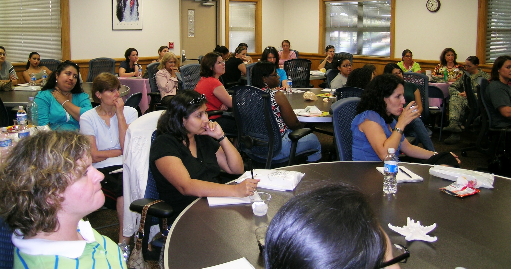 Spouses of deployed Airmen listen during a briefing at the Hearts Apart hurricane preparation party May 30 at the Airman & Family Readiness Center. More than 60 family members attended the event which is aimed at providing the spouses with information to help them better prepare for a hurricane. (U.S. Air Force photo/Tech. Sgt. Andrea Luna)