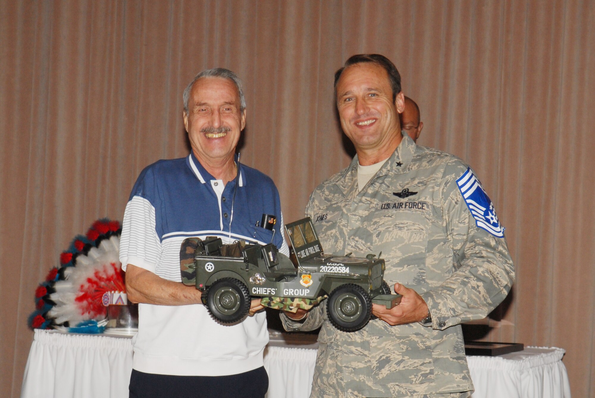 Brig. Gen. Tom Jones, 56th Fighter Wing commander, was recognized as an honorary chief master sergeant May 27. Chief Master Sgt. (ret) Geno Piccoli had the honor of bestowing the Chief’s Group Jeep to General Jones during a private ceremony. The term Jeep has traditionally been used by the military to refer to an individual who is junior or the newest. The Jeep above is symbolic of that tenure and associated with the most recently promoted chief. Therefore, the most recently promoted chief will be addressed by his/her peers as “Jeep” until a more junior chief is promoted. 