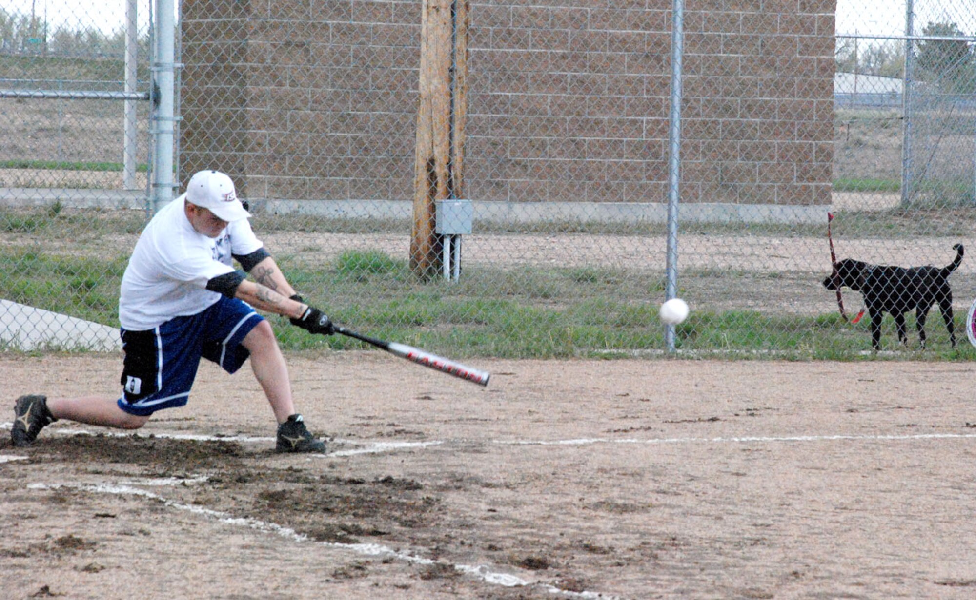 Staff Sgt. Nate Graybill, 30th AS, 153rd AW and 37th HS team, bats a low throw at the game May 28.