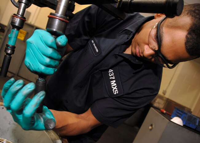 Airman 1st Class Quinton Valentine uses a computer-controlled machine to apply the proper amount of torque to two halves of a C-17 wheel. Airman Valentine is a crew chief with the 437th Maintenance Squadron. (U.S. Air Force photo/Airman 1st Class Katie Gieratz)