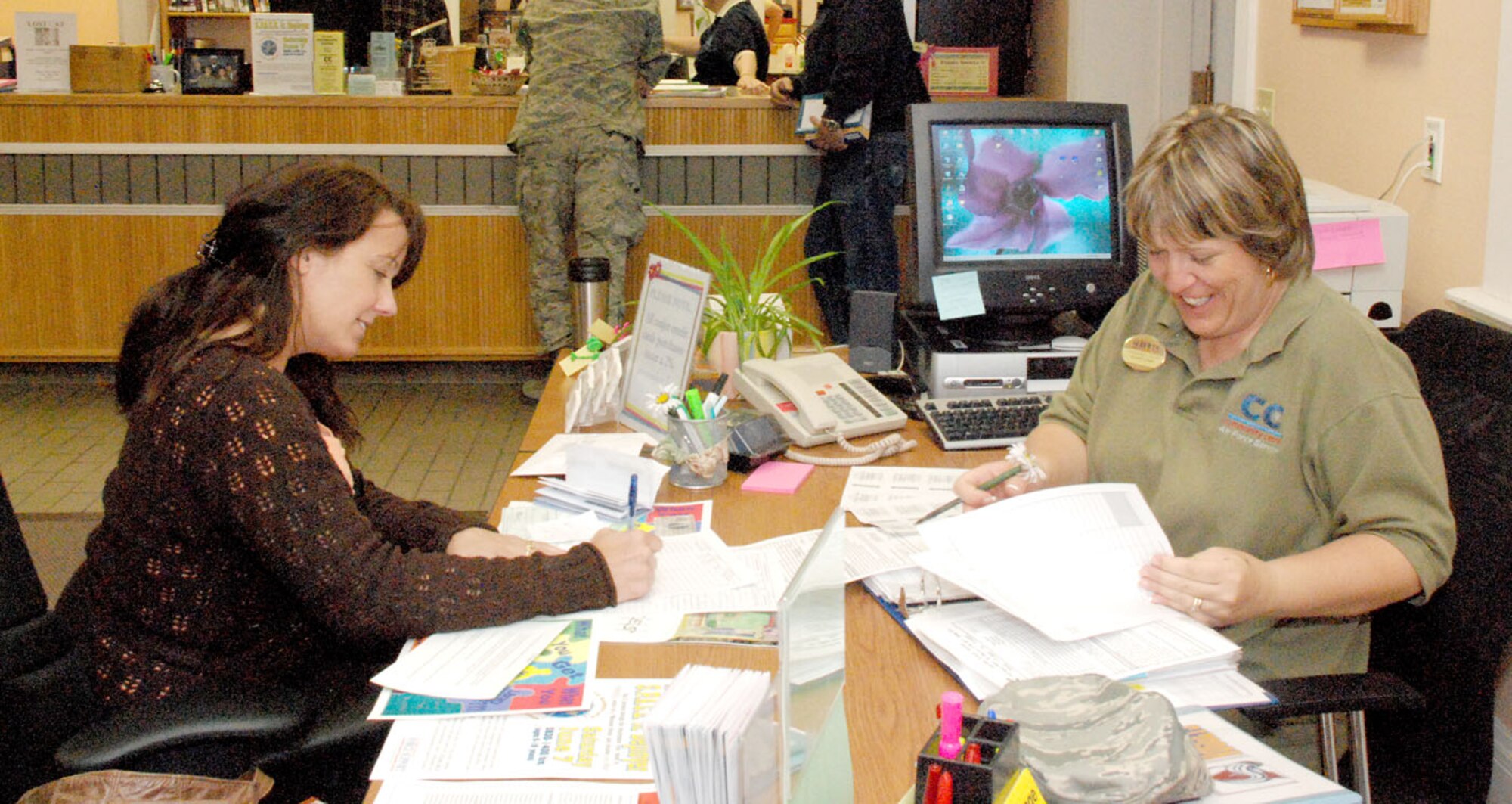 Stephanie Davis, 90th Force Support Squadron, sells zoo tickets May 22 to Kimberly Spath at the information, travel and tickets booth in the communibrary.
