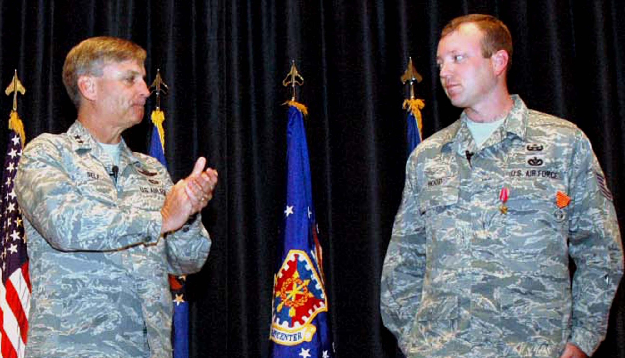 Maj. Gen. Kip Self, U.S. Air Force Expeditionary Center commander, applauds Tech. Sgt. Vandiver Hood of the Center's 421st Combat Training Squadron after presenting him with a Bronze Star and Air Force Combat Action Medal June 3, 2008, in the Center's Grace Peterson Hall at Fort Dix, N.J.  This was Sergeant Hood's second Bronze Star and AFCAM he earned for valor while deployed as part of an explosive ordnance disposal weapons intelligence team in Iraq.  He returned from that deployment in February.  (U.S. Air Force Photo/Tech. Sgt. Scott T. Sturkol)