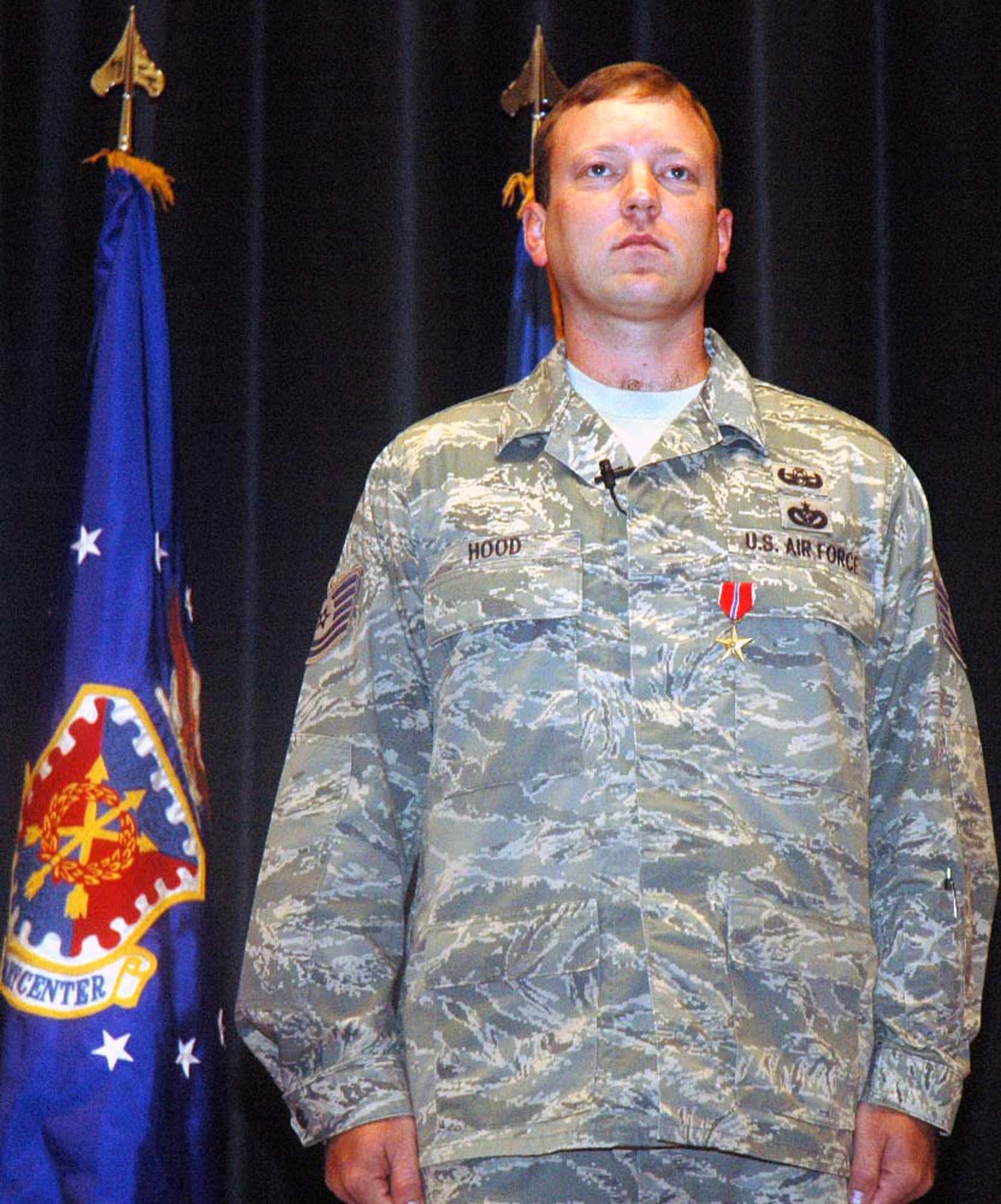 Tech. Sgt. Vandiver Hood, explosive ordnance disposal craftsman from the U.S. Air Force Exeditionary Center's 421st Combat Training Squadron, Fort Dix, N.J., stands at attention during the reading of the orders for the presentation of the Air Force Combat Action Medal in the Center's Grace Peterson Hall June 3, 2008.  Sergeant Hood was presented with his second Bronze Star and AFCAM during a special ceremony with Maj. Gen. Kip Self, USAF EC commander.  (U.S. Air Force Photo/Tech. Sgt. Scott T. Sturkol)