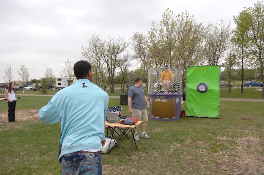 MINOT AIR FORCE BASE, N.D.—An Airman from the 5th Bomb Wing throws a ball at the target trying to dunk Chief Master Sgt. Christopher Sells, 5th Operations Group superintendent, in a dunk tank here May 29 during a base-wide picnic. Members of the 5th Bomb Wing and the 91st Space Wing came together to celebrate the beginning of summer with the picnic that included door prizes, a barbecue, a disc jockey and a bounce house for the kids.  (U.S. Air Force photo by Senior Airman Cassandra Jones)