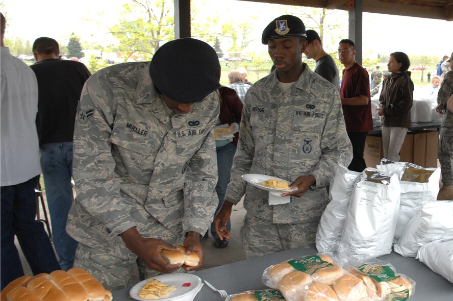 MINOT AIR FORCE BASE, N.D. — Airman 1st Class Antwane Mueller and Airman 1st Class Evans Arthur, 5th Security Forces Squadron, enjoy the food provided during a base picnic here May 29. The base-wide picnic included a dunk tank, door prizes, a barbecue, a disc jockey and a bounce house for the kids. The picnic brought members of the 5th Bomb Wing and the 91st Space Wing together to celebrate the beginning of summer. (U.S. Air Force photo by Senior Airman Cassandra Jones)