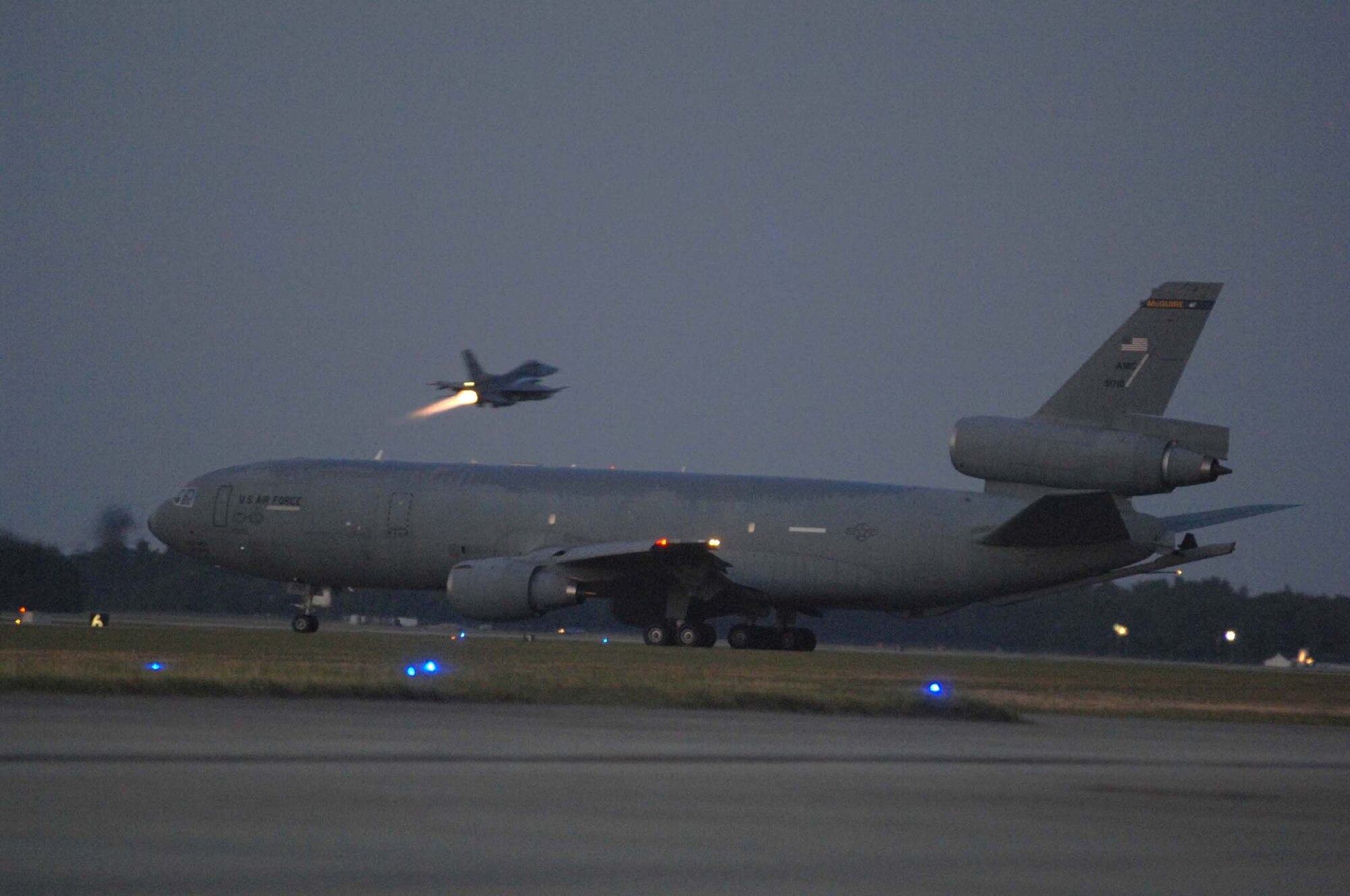SHAW AIR FORCE BASE, S.C. -- A KC-10 from McGuire Air Force Base, N.J., helps support Airmen from the 20th Fighter Wing deploy as an F-16 takes off in the back ground in the early morning. More than 200 Airmen and a dozen F-16s from the 20th Fighter Wing  deployed to Iraq to support the Global War on Terrorism. (U.S. Air Force photo/Airman 1st Class Matthew Davis)