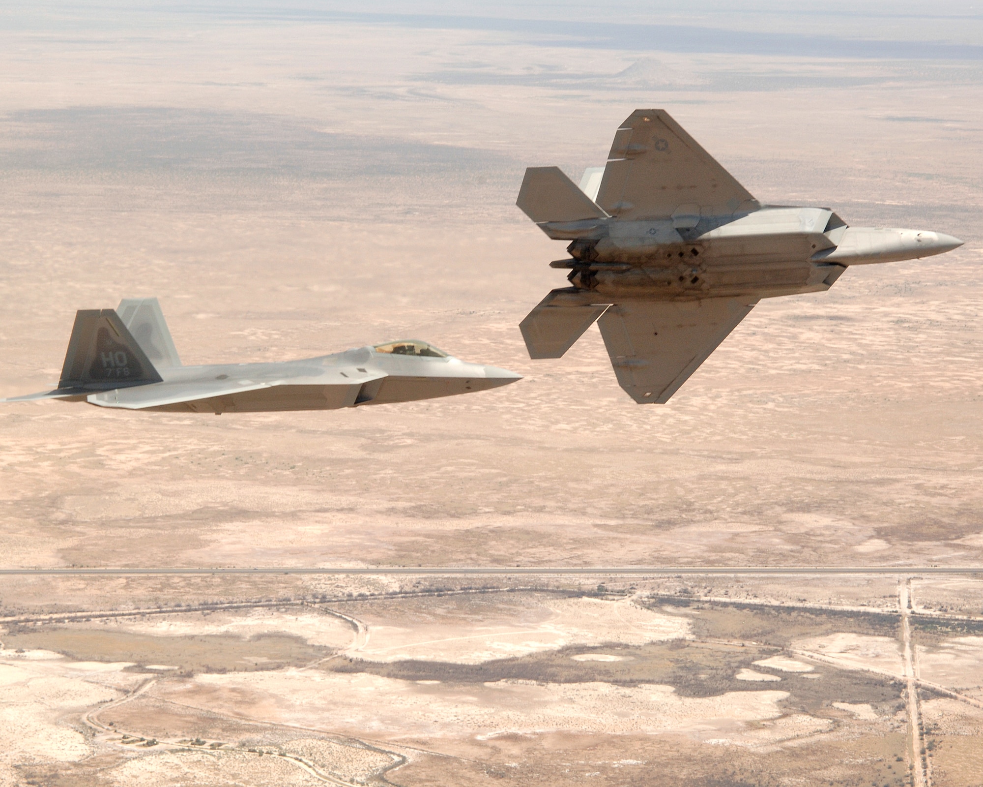 Col. Jeff Harrigian, 49th Fighter Wing commander, and Lt. Col. Mike Hernandez, 7th Fighter Squadron commander, fly a pair of F-22A Raptors over Holloman Air Force Base, N.M., in flight to the F-22 arrival ceremony June 2. The jets are the first two Holloman-tailed F-22's to arrive on base. (U.S. Air Force Photo/ Senior Airman Russell Scalf)