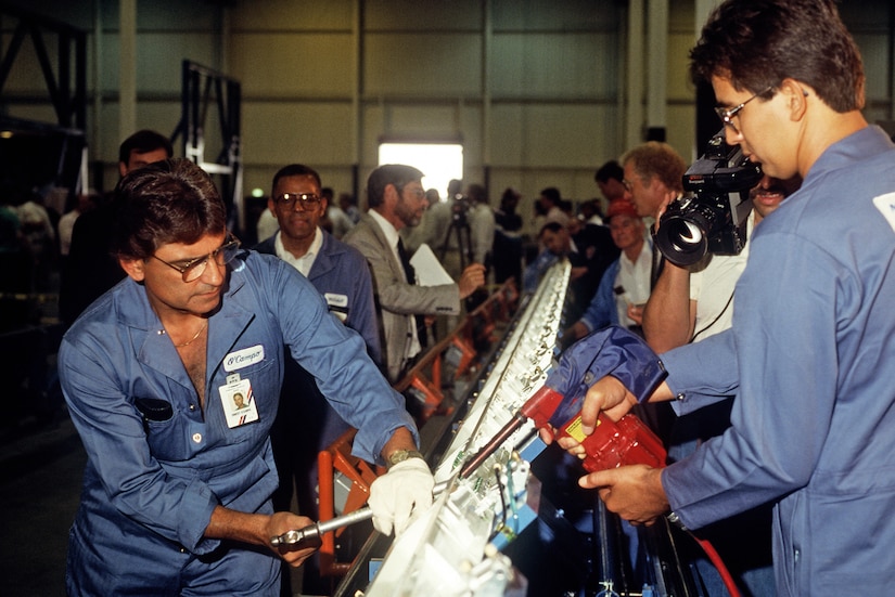 Steve Ybarra and Ernest Ocampo of Douglas Aircraft Company install fasteners on the first piece to be assembled in the C-17 transport aircraft program:  a 68-foot tiedown rail that is the central structural member of the cargo floor. The first C-17 was delivered to Charleston AFB June 14, 1993. (U.S. Air Force photo/Tech. Sgt. Bob Simmons)