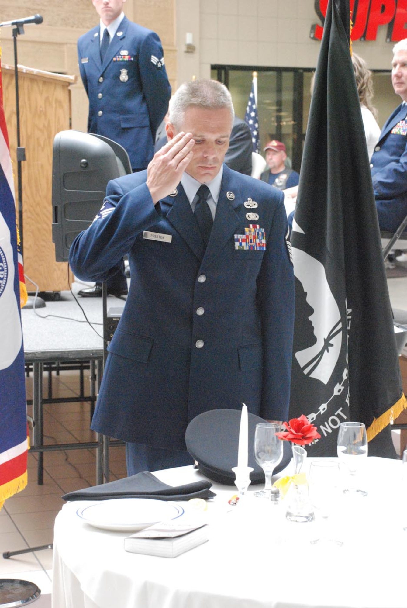 Master Sgt. Todd Preston, 30th Airlift Squadron first sergeant, pays respect to the prisoner of war and missing in action Soldiers by saluting the U.S. Armey hat on the POW/MIA table inside Frontier Mall May 17. A formal ceremony included many official military functions such as a flag folding ceremony, the playing of Taps and recognition to all branches of the Armed Forces.