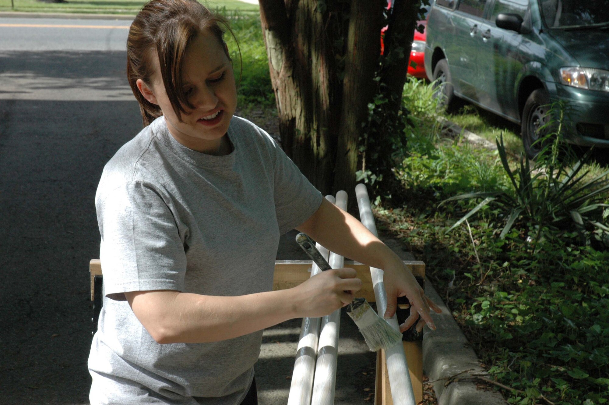 Tech. Sgt. Kristina Myers, from the U.S. Air Force Expeditionary Center, Fort Dix, N.J., paints pipes used to rebuild a flag memorial in Cherry Hill, N.J. May 28, 2008.  The memorial, created by Cherry Hill resident Michael Bloom and vandalized in April 2008, was repaired by more than 10 volunteers from the USAF EC. It has more than 4,000 American flags posted honoring all the U.S. military members lost in Operation Iraqi Freedom. (U.S. Air Force Photo/Staff Sgt. Paul R. Evans)