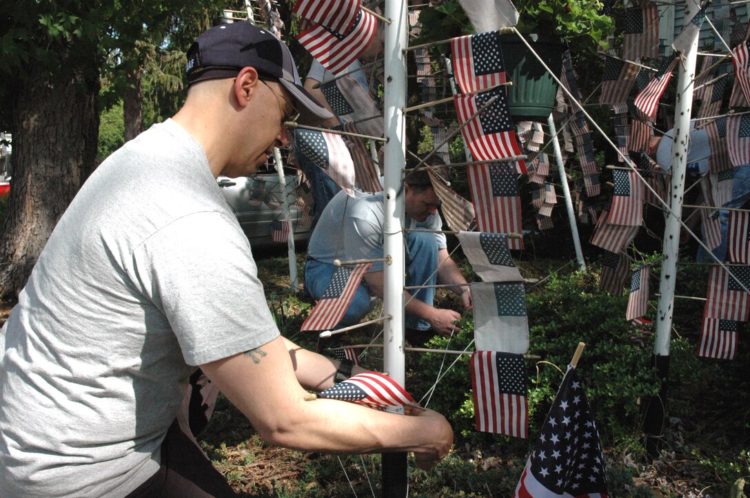 Senior Master Sgt. Dom Perino, from the U.S. Air Force Expeditionary Center, Fort Dix, N.J., carefully places a fallen flag back into its position of honor at a flag memorial in Cherry Hill, N.J. May 28, 2008.  The memorial, created by Cherry Hill resident Michael Bloom and vandalized in April 2008, was repaired by more than 10 volunteers from the USAF EC. (U.S. Air Force Photo/Staff Sgt. Paul R. Evans)