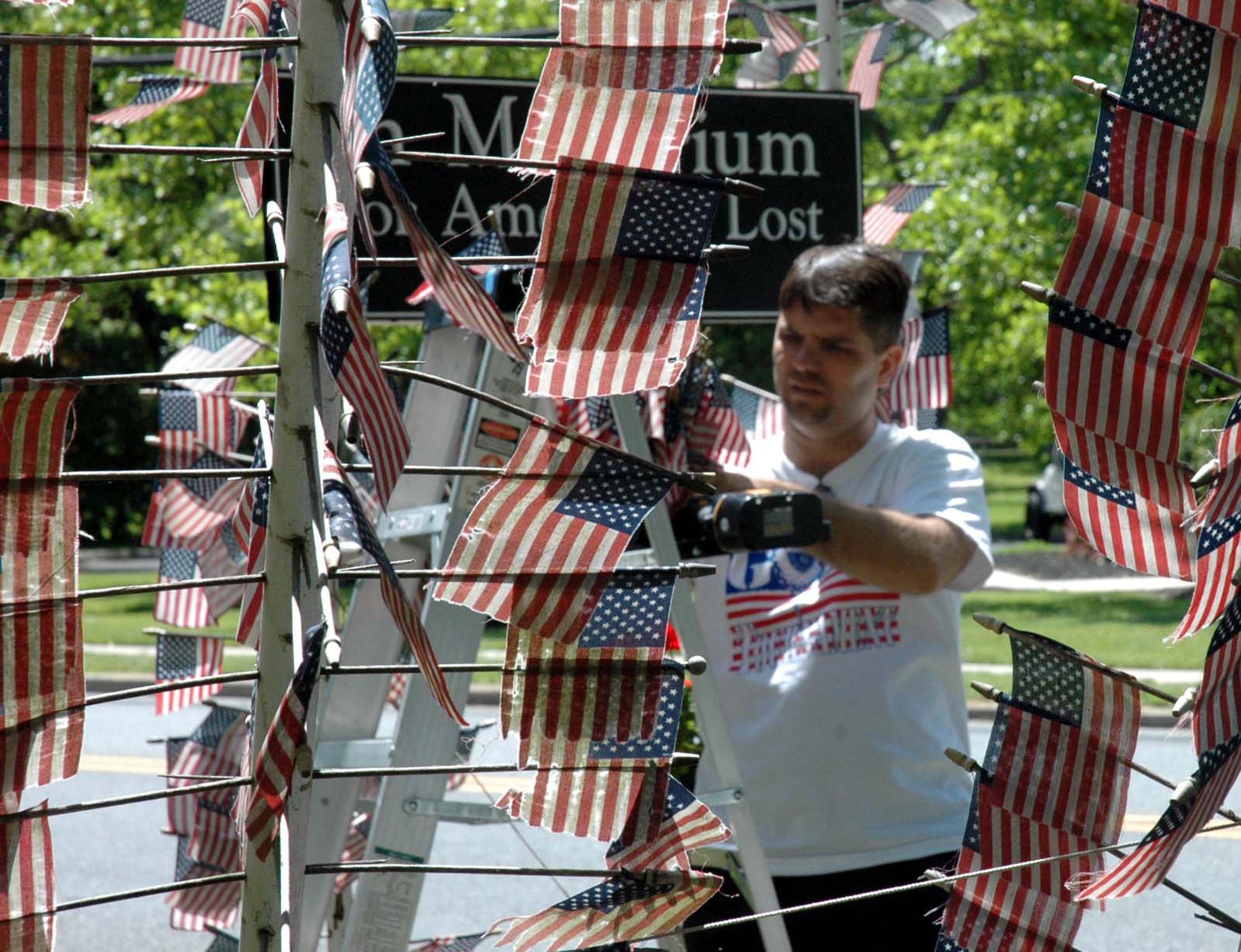 Master Sgt. Joseph Kazimer, from the U.S. Air Force Expeditionary Center, Fort Dix, N.J., repairs a vandalized flag memorial in Cherry Hill, N.J., May 28, 2008, as part of a community service project by more than 10 volunteers from the USAF EC.  The memorial, built by Cherry Hill resident Mr. Michael Bloom, is a tribute to the fallen U.S. service members of Operation Iraqi Freedom and has more than 4,000 American flags displayed. (U.S. Air Force Photo/Staff Sgt. Paul R. Evans)