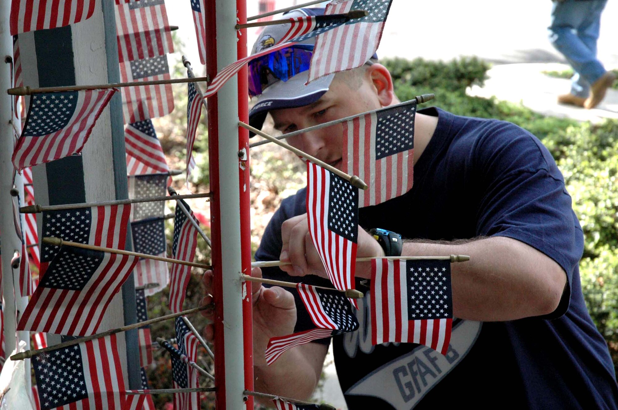 Master Sgt. Timothy Wasut, first sergeant for the U.S. Air Force Expeditionary Center, Fort Dix, N.J., carefully places a fallen flag back into its position of honor at a flag memorial in Cherry Hill, N.J. May 28, 2008.  The memorial, created by Cherry Hill resident Michael Bloom and vandalized in April 2008, was repaired by more than 10 volunteers from the USAF EC. (U.S. Air Force Photo/Staff Sgt. Paul R. Evans)
