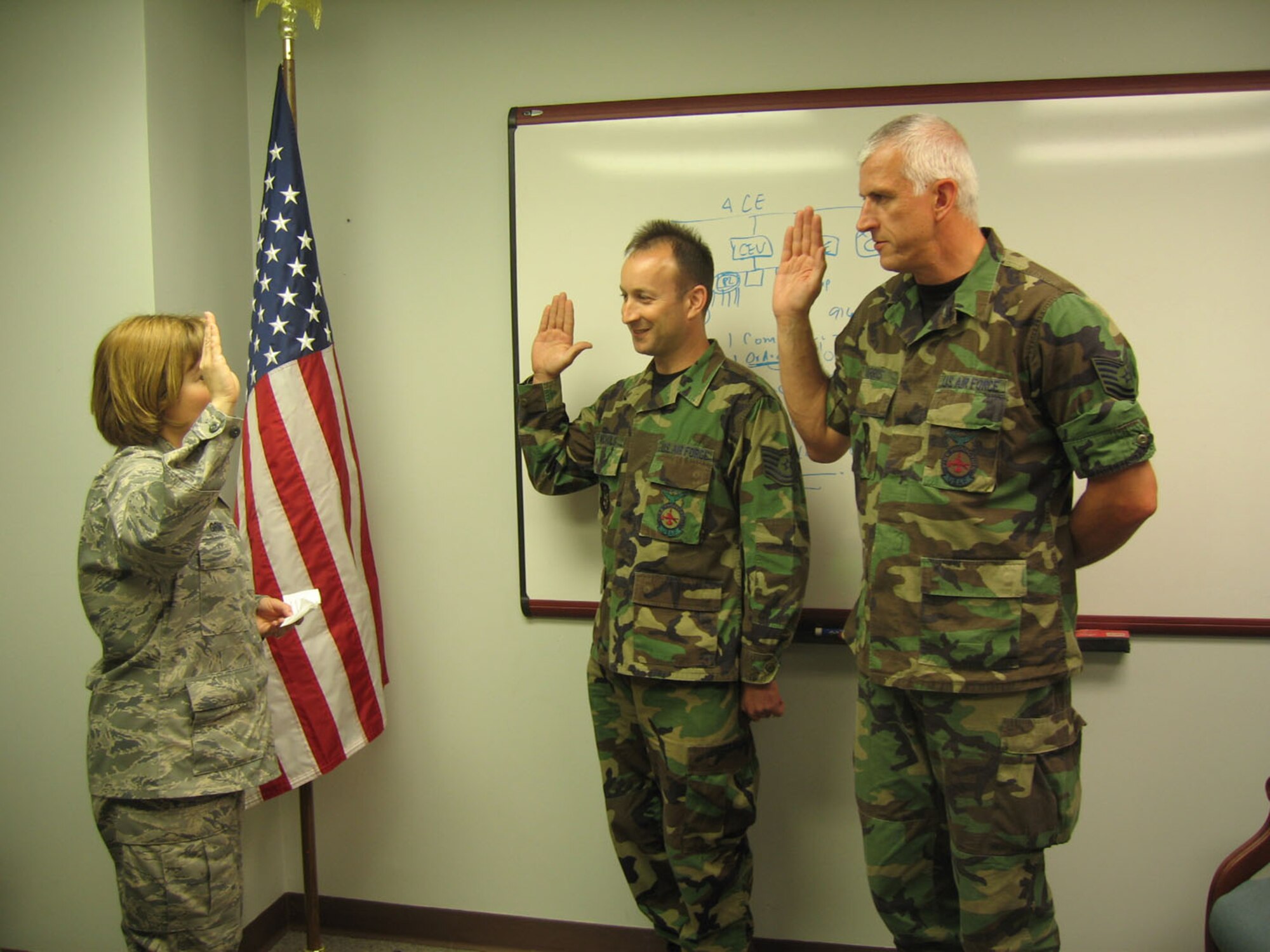 SEYMOUR JOHNSON AIR FORCE BASE, N.C. -- Tech. Sgts. Robert Harris and John Nichols take their re-enlistment oath during the May unit training assembly. Lt. Col. Kerri Grimes (left), commander of the 916th Civil Engineer Squadron, administers the oath. Both reservists serve as fire protection specialists with the 916th Fire Department.