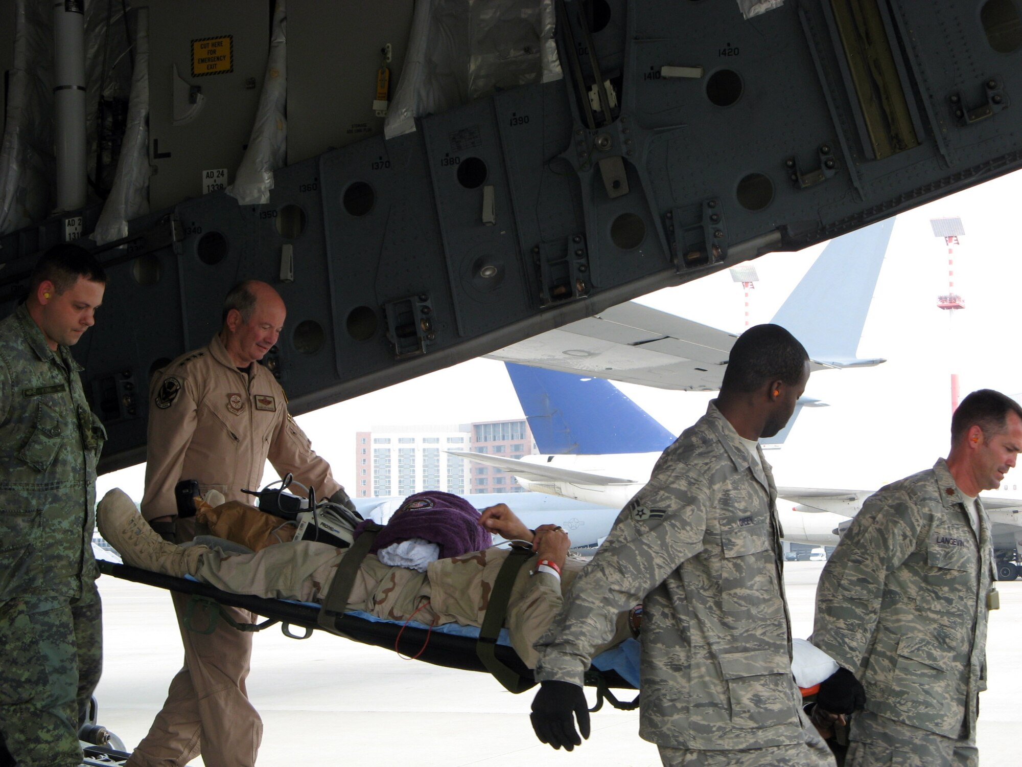 Gen. Duncan J. McNabb helps Contingency Aeromedical Staging Facility members transport an injured contractor May 29 upon landing at Ramstein Air Base, Germany. General McNabb traveled to the Air Force Theater Hospital at Balad AB, Iraq, to visit wounded warriors and accompany them on a flight back to Ramstein AB. General McNabb is the Air Force vice chief of staff. (U.S. Air Force photo) 