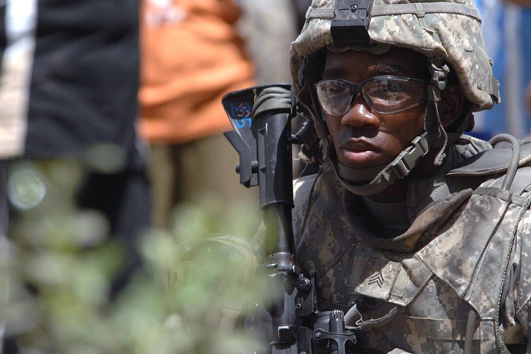U.S. Army Sgt. Dajuan Turner maintains security outside a school where Iraqi men are signing up for a local neighborhood watch program in the Sadr City district of Baghdad, Iraq, May 30, 2008.
