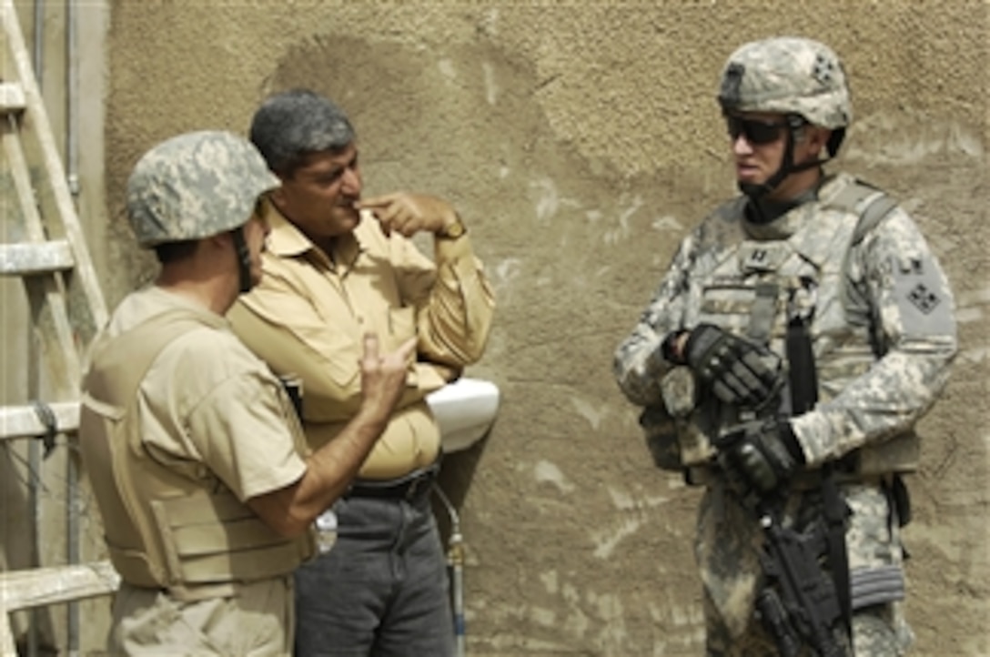 U.S. Army Capt. Kelly Lanphere (right) and interpreter Nima Alsaiagh speak with a worker at the Actives Council building in Amariyah, Iraq, on May 5, 2008.  Lanphere is from Hatchet Troop, 4th Squadron, 10th Cavalry Regiment, 4th Infantry Division.  