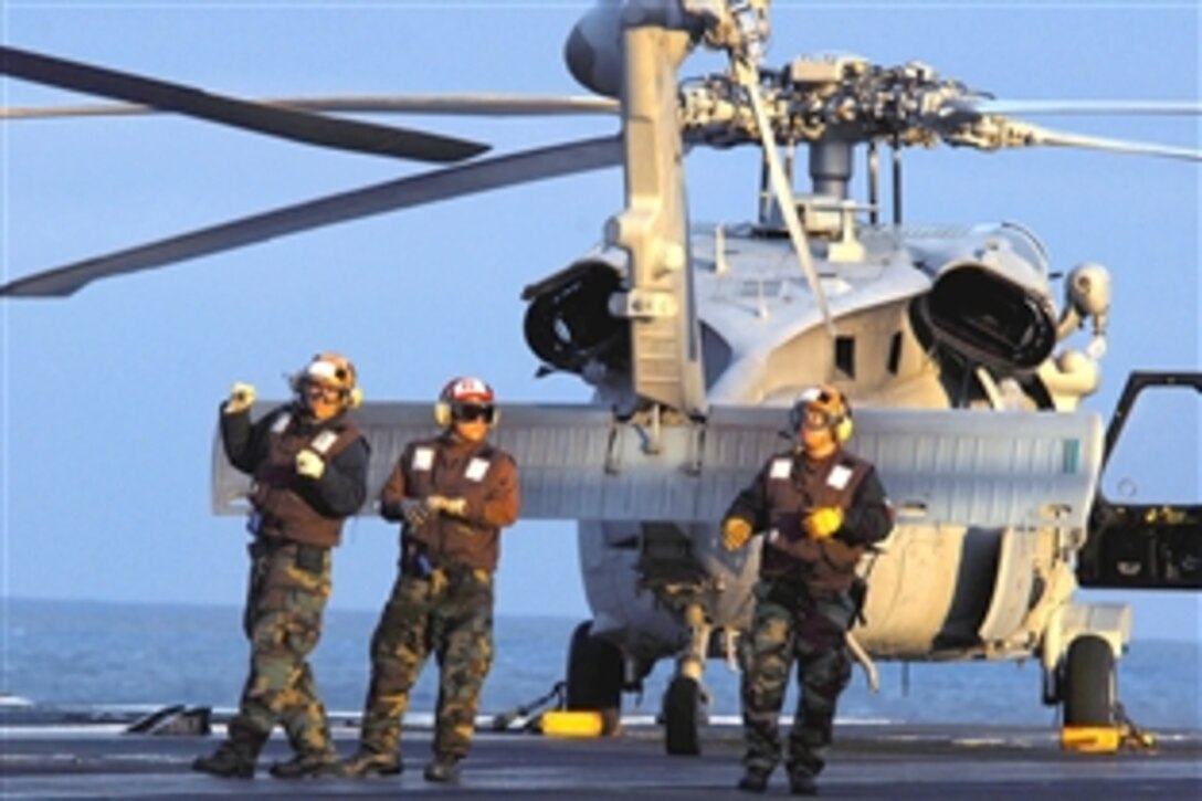 U.S. Navy sailors assigned to the aircraft carrier USS John C. Stennis walk the flight deck after performing a final pre-flight check on an MH-60S Seahawk helicopter off Southern California, May 31, 2008. 