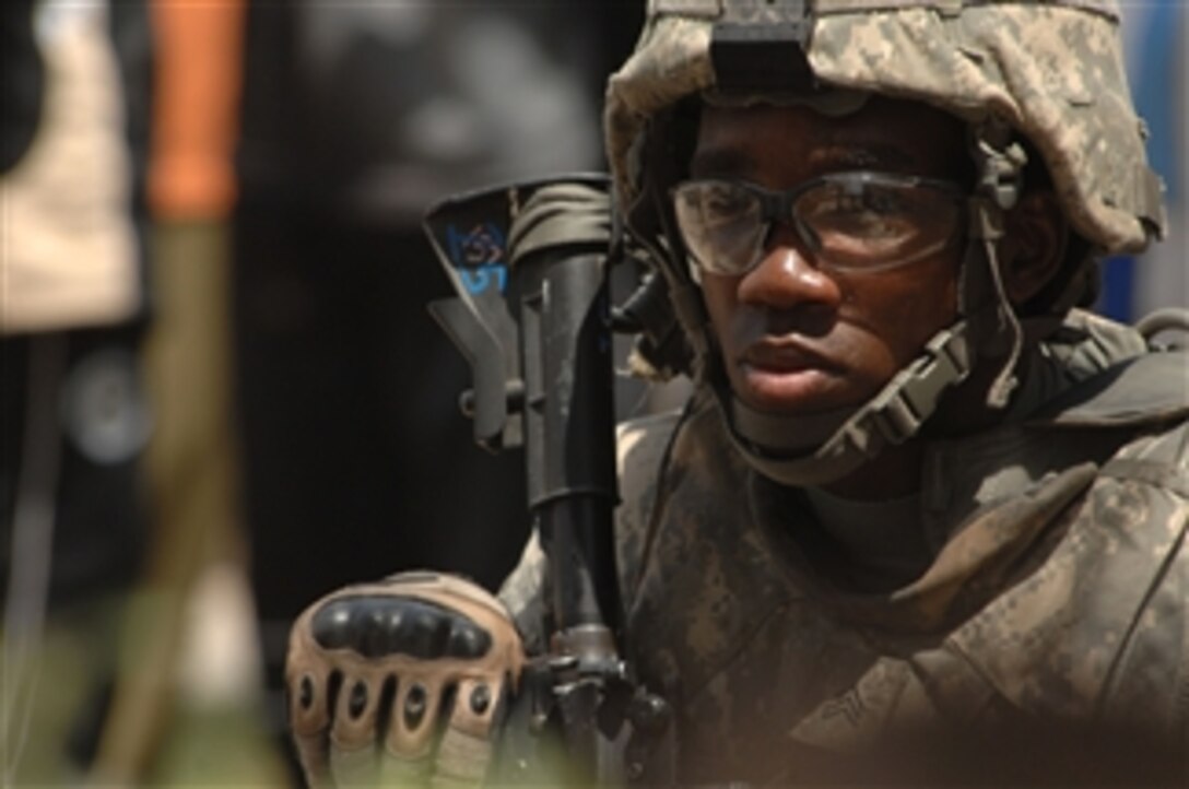 U.S. Army Sgt. Dajuan Turner provides security outside a school in the Sadr City district of Baghdad, Iraq, on May 30, 2008.  Inside the school, more than 100 Iraqi men are applying for positions in the local neighborhood watch program.  Turner is assigned to the 3rd Brigade Combat Team, 4th Infantry Division, as part of Task Force Regular.  