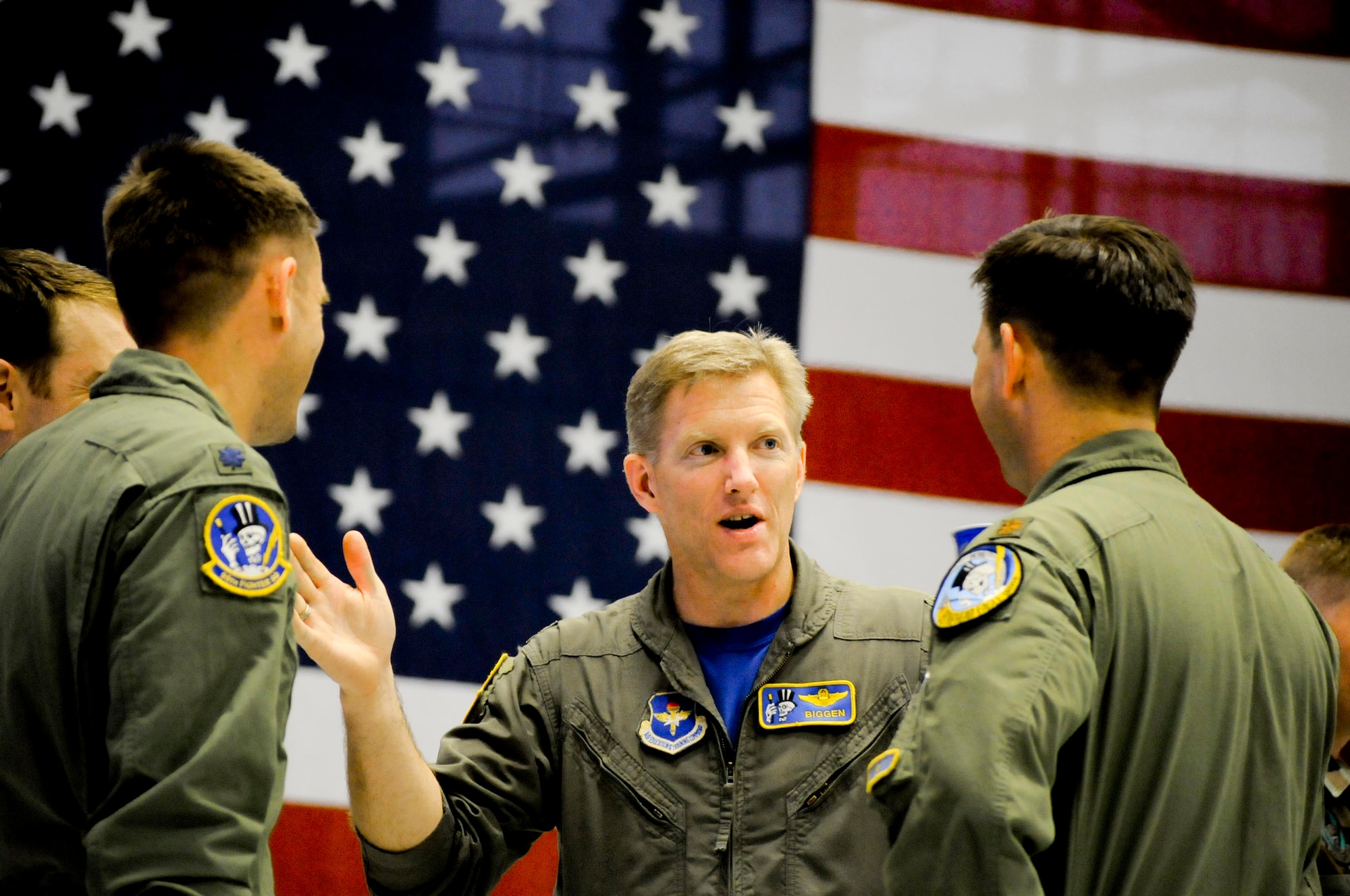 Maj. Brian Johnson (center), 95th Fighter Squadron instructor pilot, shares stories with Maj. Nick Kavouras (right) and Lt. Col. Kent Hobson, fellow 'Bonehead' instructor pilots, during the reunion social held May 30.  Current members of the 95th Fighter Squadron and Maintenance Unit gathered with veteran 'Boneheads' for a dinner and social event during the 2008 'Bonehead' Reunion. (Photo by Capt. Justin Ripley)