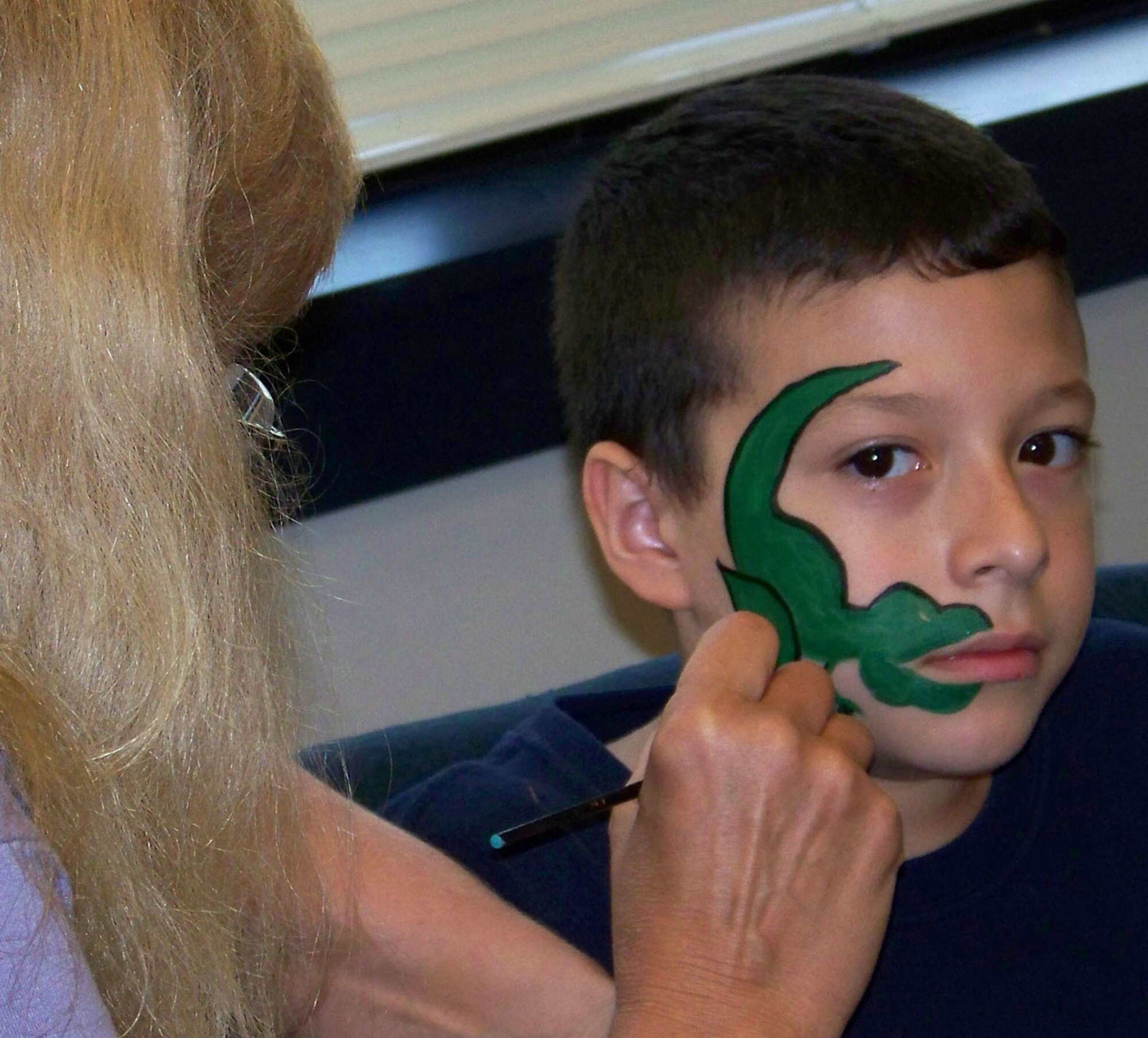 Neecee Blackwell, local graphic artist, paints the face of Cade Feliciano, son of Staff Sgt. Joshua Feliciano, 917th Security Forces Squadron, during the 917 SFS Family Day Wednesday, June 4, Barksdale AFB, La. (U.S. Air Force photo/Master Sgt. Sherri Bohannon)