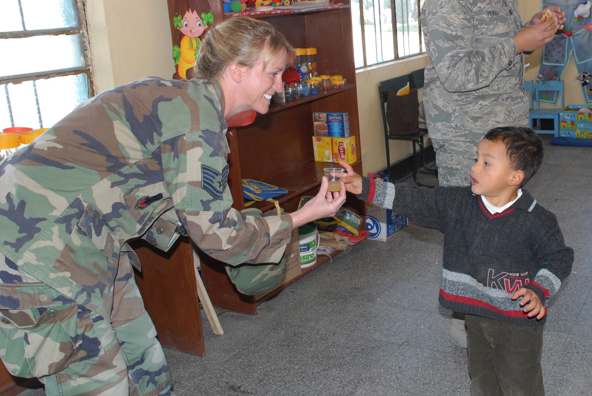 Tech. Sgt. Cari Gebbia, a paralegal deployed from the 12th Air Force Legal Office at Davis-Monthan Air Force Base, Ariz., accepts a cup of juice from Rodrigo Guillermo Marquina Baluarte, 3, during a visit to I.E. Inicial CRL. Miguel Peñarrieta Elementary School June 4 in Los Cabitos, Peru, the location where U.S. military members are based in support of New Horizons Peru 2008, a humanitarian event that benefits thousands of Peruvians. (U.S. Air Force photo/Airman 1st Class Tracie Forte)