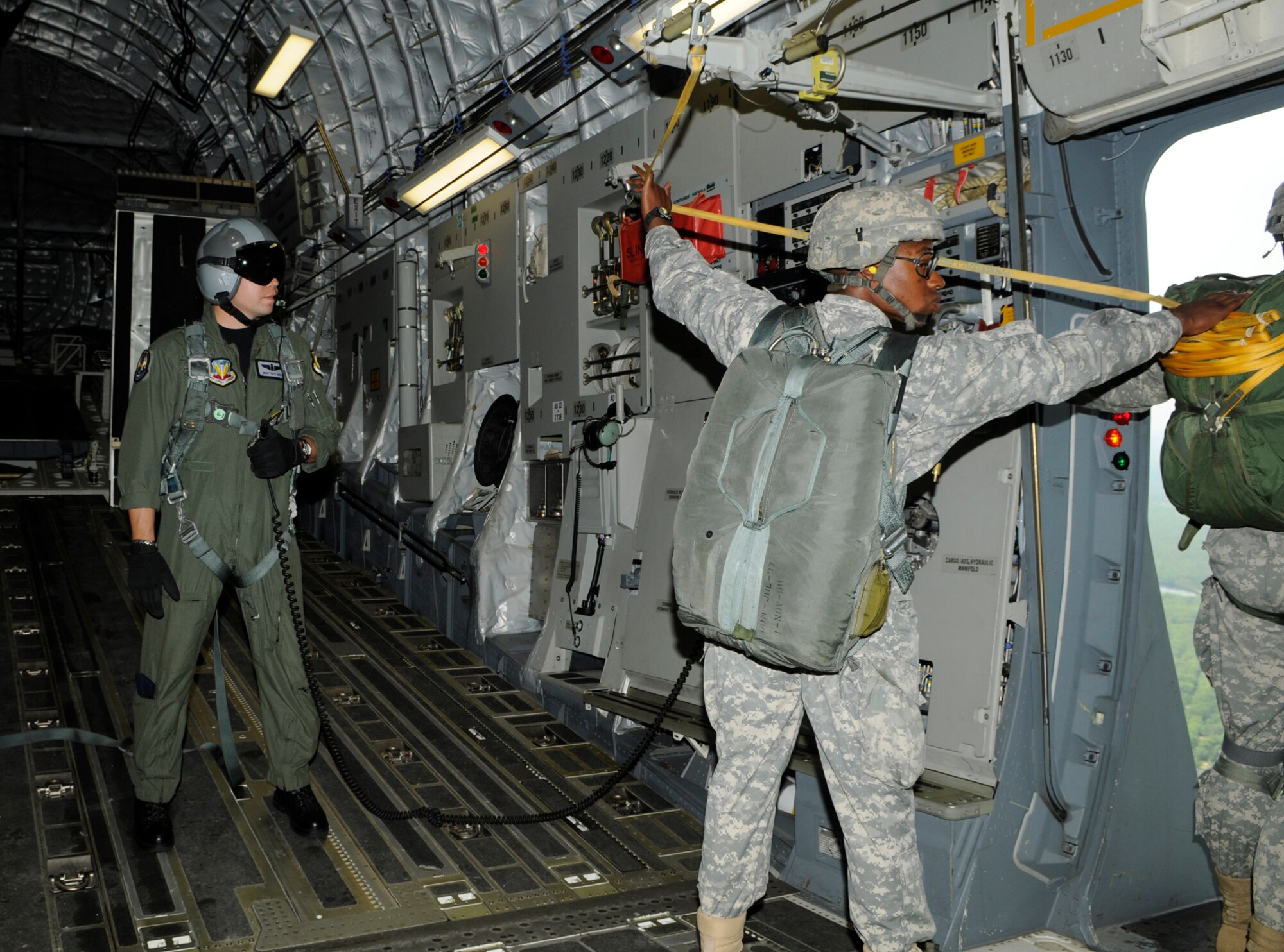 Master Sgt. Pete Moss, 57th Weapons Squadron loadmaster, watches as Jumpmaster Staff Sgt. Montrell Kea, 82nd Airborne Division, Fort Bragg, N.C., prepares paratroopers for their jump. The team dropped out of a C-17 Globemaster III during the 2008 McGuire Air Expo held May 31 and June 1. (U.S. Air Force photo/Kenn Mann)
