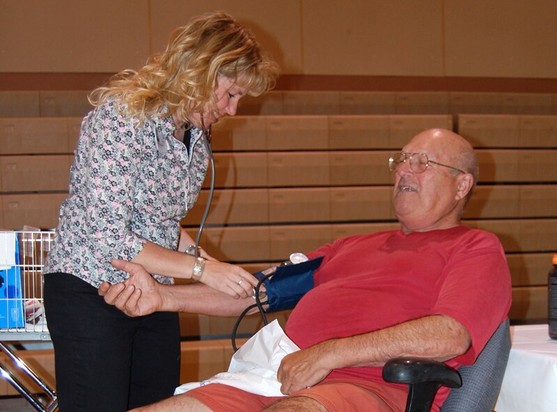 Janae Ruckman, Benefis Health Care licensed practical nurse, takes retired Tech. Sgt. Walter Albert's blood pressure in the lower gym of the base fitness center during a health fair hosted by the 341st Services Squadron May 30. In addition to Benefis Health Care's booth on cardiovascular health for men and women, the health and wellness center, GNC, outdoor recreation, the youth programs center, the American Red Cross, and other non-profit organizations were also handing out fitness products like water bottles, jump ropes and health information. (U.S. Air Force photo/Airman 1st Class Dillon White) 
