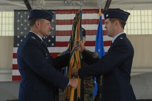 Lt. Col. Wade Tolliver. (left), previous 27th Fighter Squadron commander, hands the unit flag to the new 27th FS commander, Lt. Col. Lansing Pilch, during a change of command ceremony here May 30. (U.S. Air Force photo/Senior Airman Cecil C.McCloud)