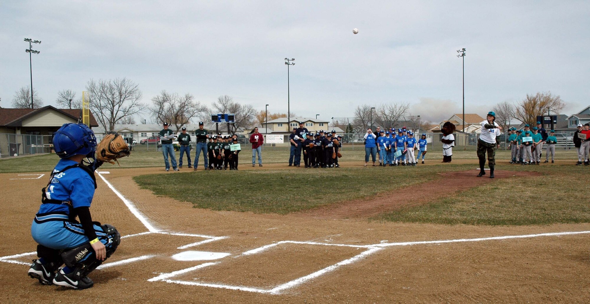 Andrew Garrison gets into position to catch the first pitch of the 2007 Little League season from then 341st Space Wing commander Col. Sandra Finan. Andrew was also selected this year to catch the first pitch. (U.S. Air Force file photo)