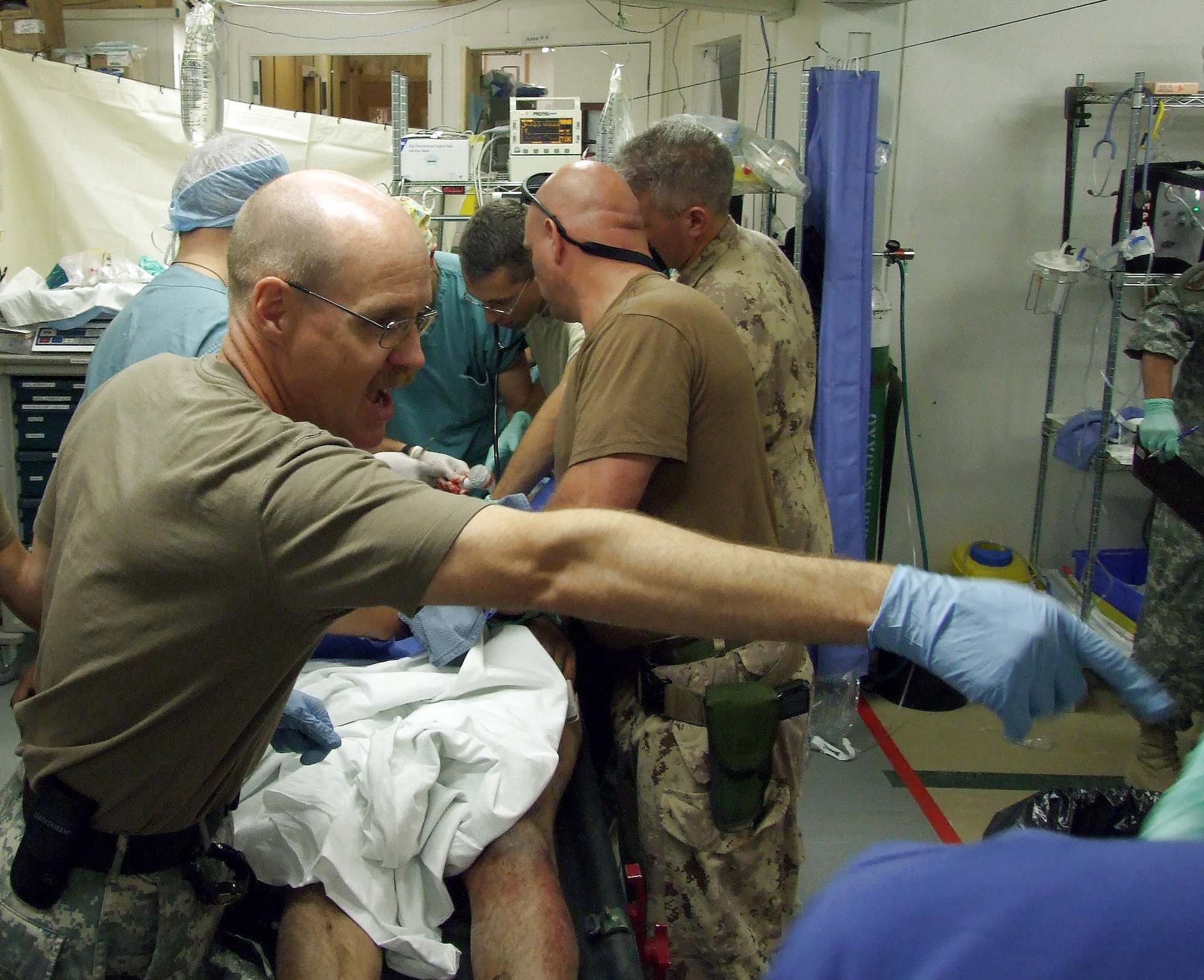 Col. (Dr.) Thomas Seay (left) assists with a trauma Sept. 1 at the Role 3 Multinational Medical Unit at Kandahar Air Field in Afghanistan. Colonel Seay was recently awarded the Canadian Meritorious Service Medal for outstanding service while deployed to the hospital. Colonel Seay is the 59th Radiology Squadron commander at Wilford Hall Medical Center, Lackland Air Force Base, Texas. (U.S. Air Force photo) 