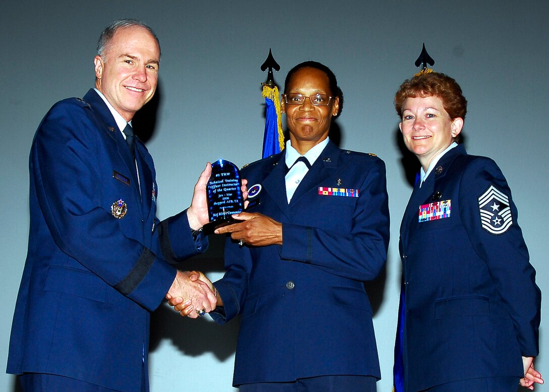 Brig. Gen. Richard Devereaux, 82nd Training Wing commander, presents Maj. Mimi Cannonier, 383rd Training Squadron, with the Officer Military Training Leader of the Quarter award, June 2. (U.S. Air Force photo/Harry Tonemah) 