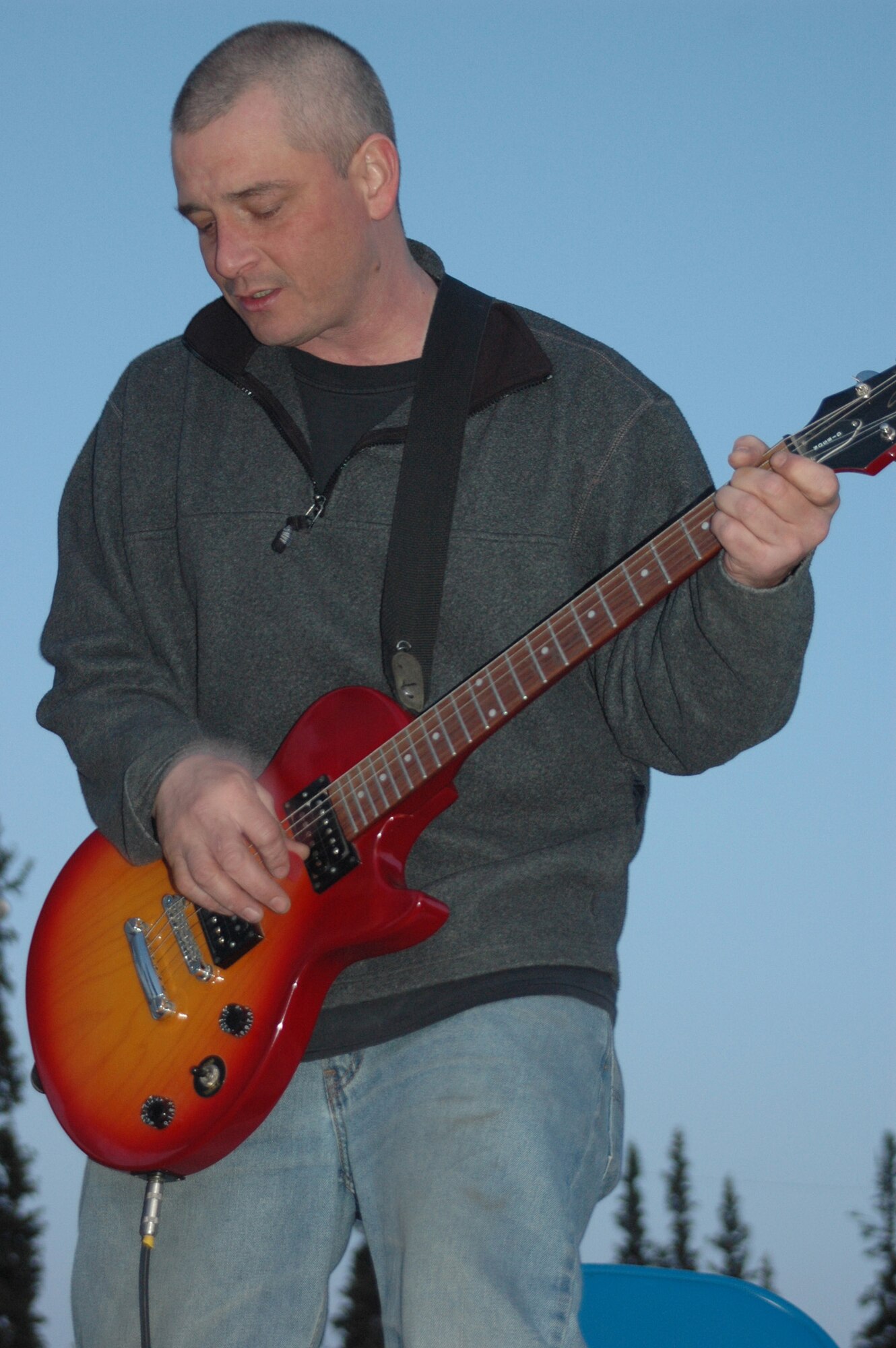 Tech. Sgt. John Kehres, 354th Aircraft Maintenance Squadron weapons crew chief, plays guitar in his band, Dystopia, at a cancer benefit May 31 at the West Valley High School in Fairbanks. Sergeant Kehres has been playing guitar for 24 years. Dystopia plays a myriad of songs from 90s-era bands such as Stone Temple Pilots; Alice in Chains and Rage Against the Machine. (U.S. Air Force photo by Airman 1st Class Nora Anton)