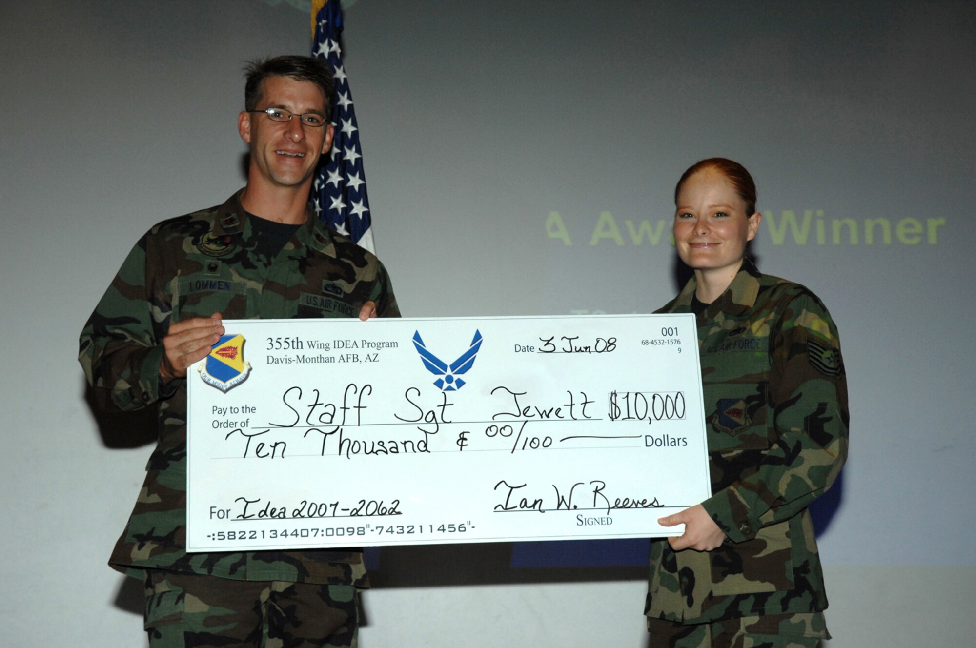 Maj. Peter Lommen, 355th Component Maintenance Squadron commander, presents Tech. Sgt. Julie Jewett a check for $10,000 for her contributions to the Air Force through the Inovative Development through Employee Awareness program here June 3. (U.S. Air Force photo by Airman 1st Class Noah R. Johnson)