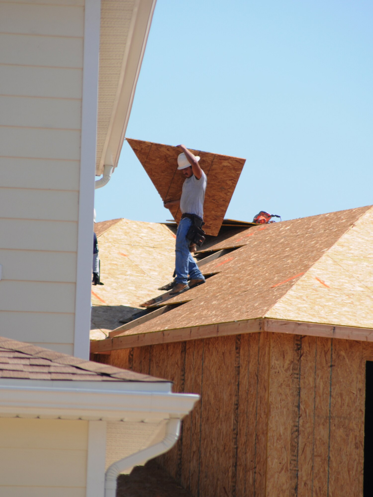 Marcos Flores works on the roof of one of the 136 housing units homes under construction in Northwest Falcon Park.  (U.S. Air Force photo by Kemberly Groue)