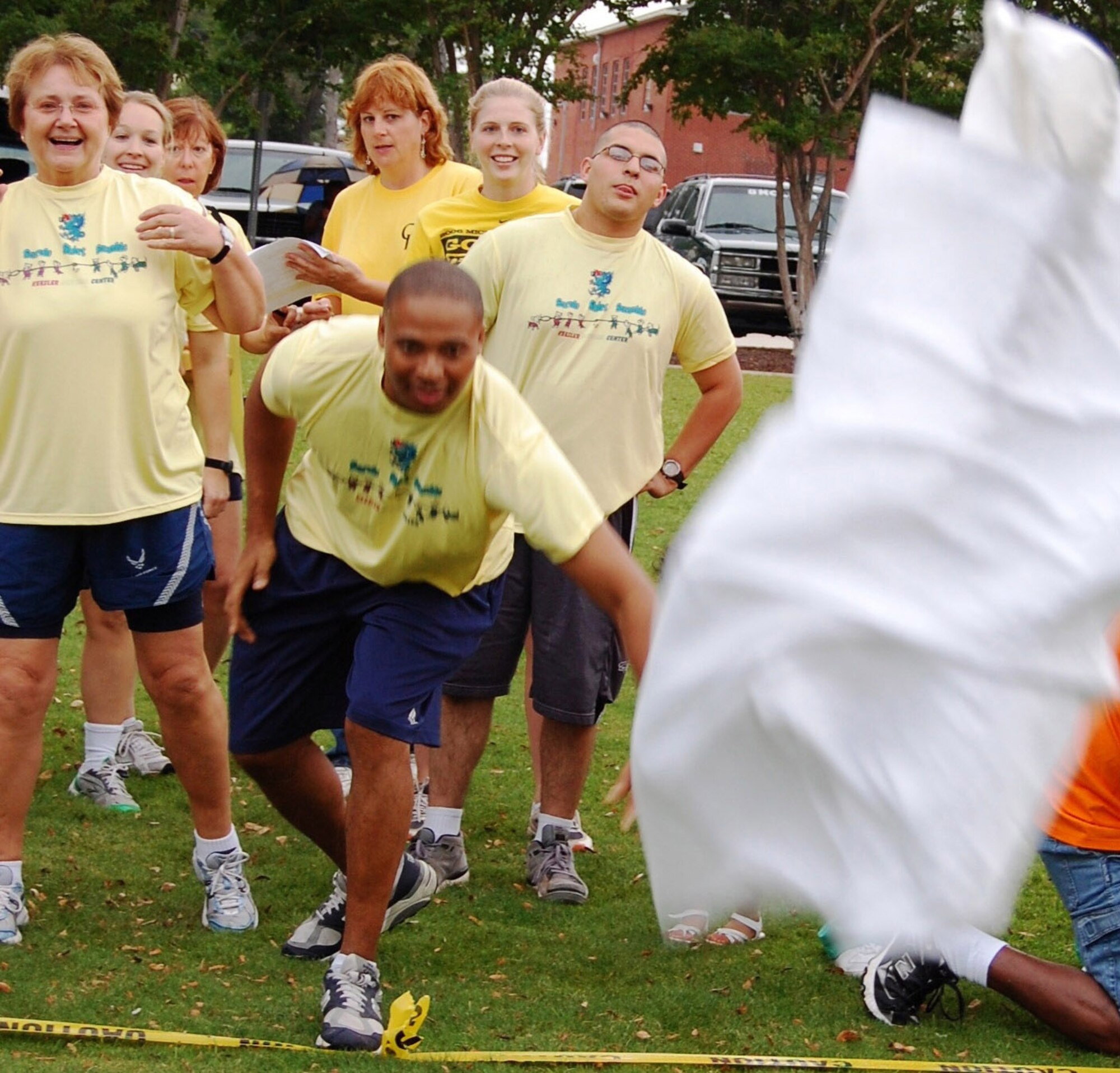 Tech. Sgt. Donelle Clark, center, 81st Surgical Oper-ations Squadron, tosses a bag of laundry in the laundry pitch.   Keesler team members cheering him on are, from left, Maj. Alina Khalife, 81st Inpatient Operations Squadron; Capt. Hillary John-ston, 81st MSGS; Col. Eliza-beth Bowers-Klaine, 81st MDG; 2nd Lt. Emily Brakora, 81st IPTS; Airman Gilbert Helton, 81st Medical Opera-tions Squadron; and 2nd Lt. Mary Peterson, 81st MSGS.  (U.S. Air Force photo by Steve Pivnick)