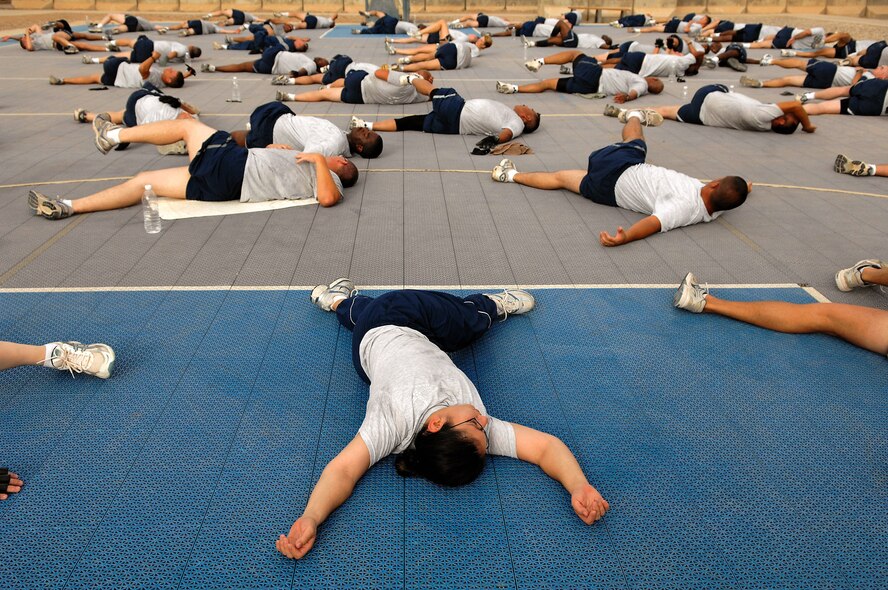 Airmen assigned to the 557th Expeditionary RED HORSE Squadron stretch after a group workout session June 3 at Balad Air Base, Iraq. The unit meets each morning,  workout as a unit and promote the Air Force's fit-to-fight lifestyle . The 557th ERHS staff provides direct support to the Army' 20th Engineer Brigade for large-scale construction projects throughout Iraq. (U.S. Air Force photo/Senior Airman Julianne Showalter) 