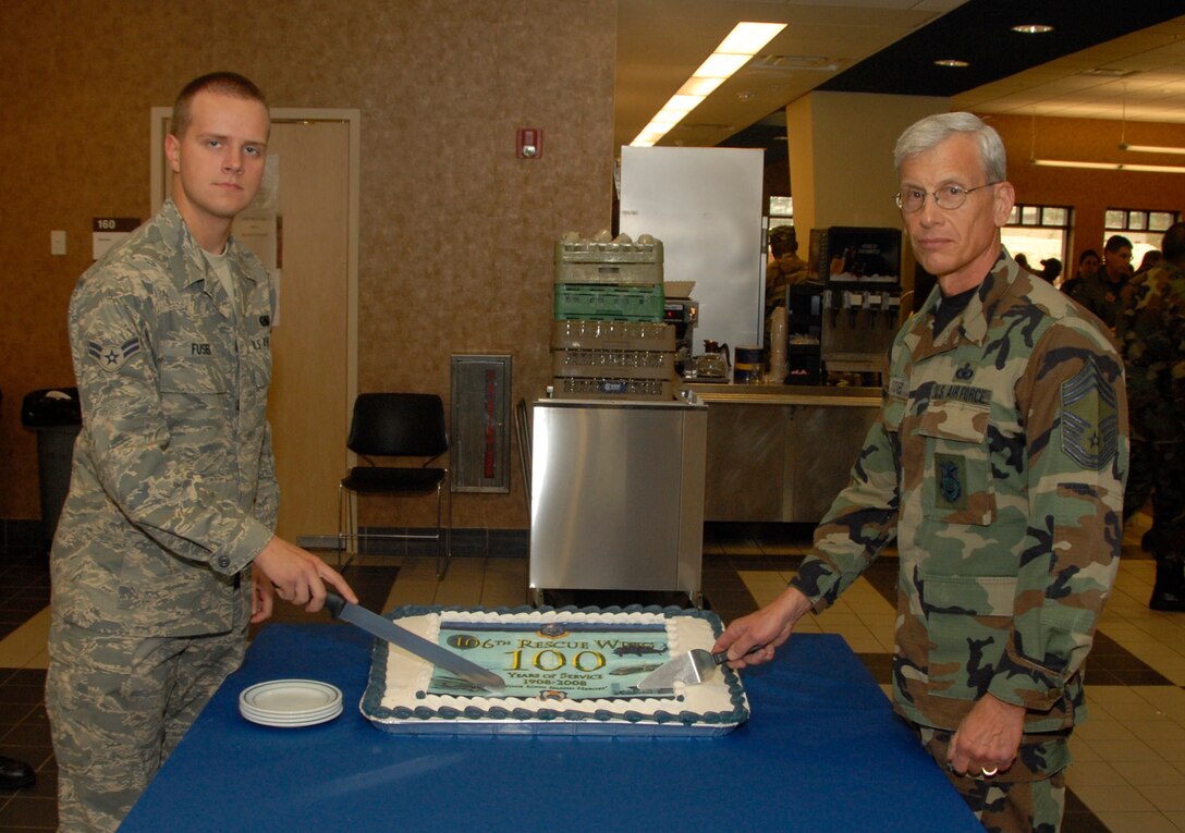 F.S. Gabreski Airport, Westhampton Beach, N.Y. --
On May 5, 2008 the longest serving member of the 106th Rescue Wing, Chief Master Sgt. Peter K. E. Adickes, along with the newest member, Airman 1st Class Mateusz Fusiek, helped celebrate the 100 years of the 106th on May 4th. The two Wing members worked together to help cut the special 100th anniversary cake in the Prime Ribs dining hall. 
(Official USAF Photo by Staff Sgt. David J. Murphy)
