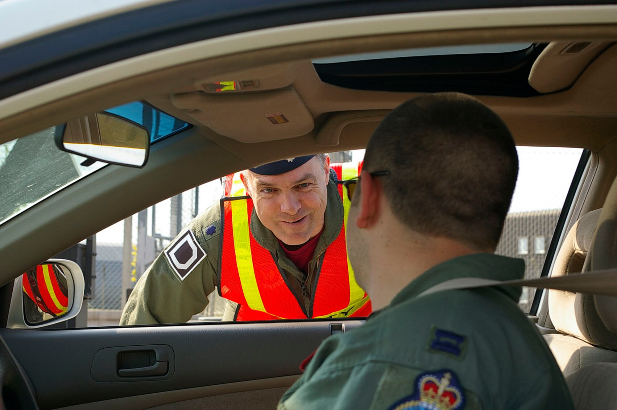 Lt. Col. Gary Slack, 100th Air Refueling Wing Safety chief, stops a Team Mildenhall member as he prepares to exit the base May 23 at the start of the 101 Critical Days of Summer. Wing leadership, along with the 100th ARW Safety Office, were at the main exit gate and the West Row Gate handing out pens and other small items, reminding people to be safe and drive safely, as 101 Critical Days of Summer kicked off May 26. (U.S. Air Force photo by Karen Abeyasekere)