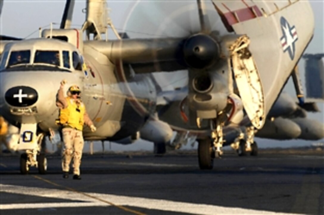 U. S. Navy Chief Petty Officer Christopher Gantz gives the signal to take command of an aircraft while an E-2C Hawkeye waits to taxi toward catapult one on the flight deck aboard the aircraft carrier USS John C. Stennis off Southern California, May 29, 2008. 