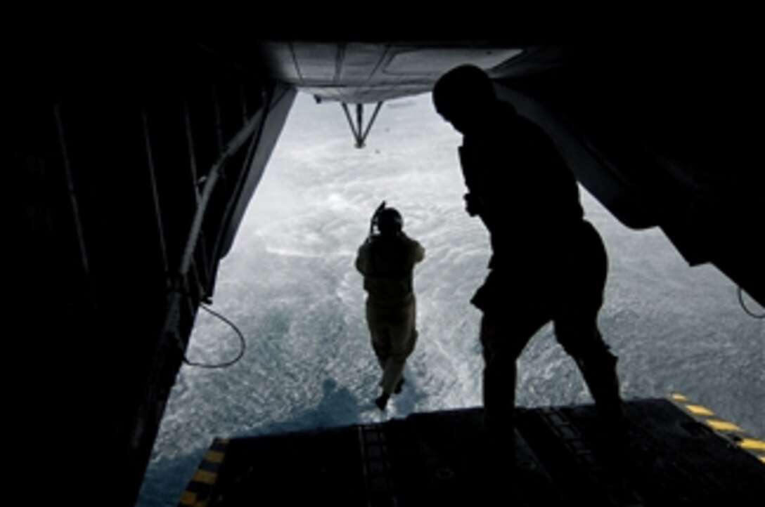 U.S. Navy Diver 1st Class Adam Eddingfield (left) from Explosive Ordnance Disposal Mobile Unit 8, out of Sigonella, Italy, jumps off the back ramp of an MH-53 Pave Low helicopter assigned to Marine Heavy Helicopter Squadron 464 over the Gulf of Aden during a training mission on May 31, 2008.  Eddingfield is deployed to Combined Joint Task Force - Horn of Africa out of Camp Lemonier, Djibouti.  