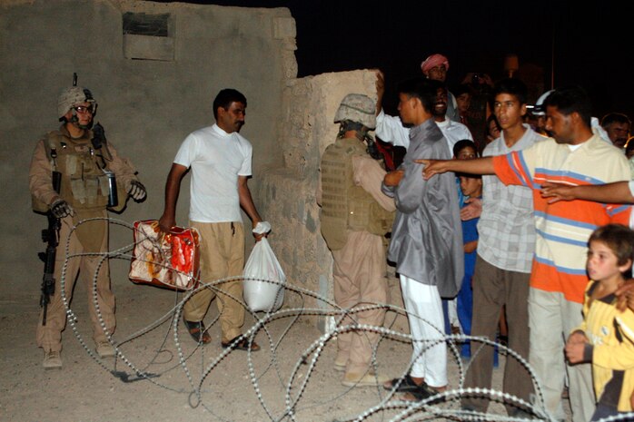 Village members of Fuhaylat gather to collect food bags here, June 4. Coalition Forces came to assist neighboring villagers in the area and build a relationship with the people.