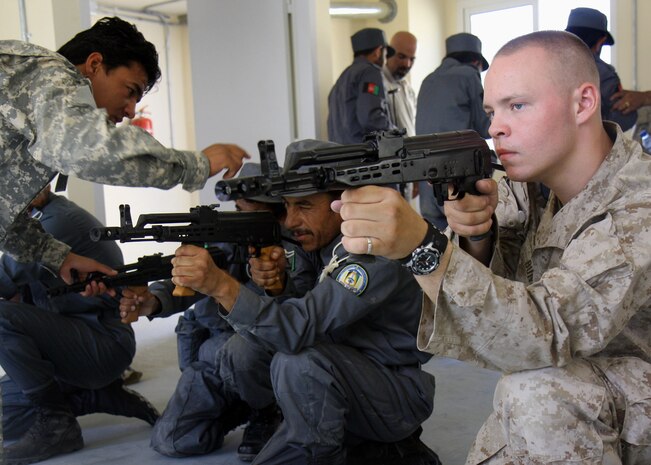 Lance Cpl. Joshua S. Bunn, Company F, 2nd Battalion, 7th Marine Regiment demonstrates to Afghan National Police Recruits firing positions with the AMD-65 on Lashkar Gah, June 4. 2nd Battalion 7th Marines, based out of Marine Air Ground Combat Center 29 Palms, is a reinforced light infantry battalion deployed to Afghanistan in support of Operation Enduring Freedom.